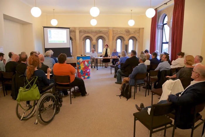 Meeting Room in St Peter's Church, Eaton Square, with attendees engaged in a presentation.