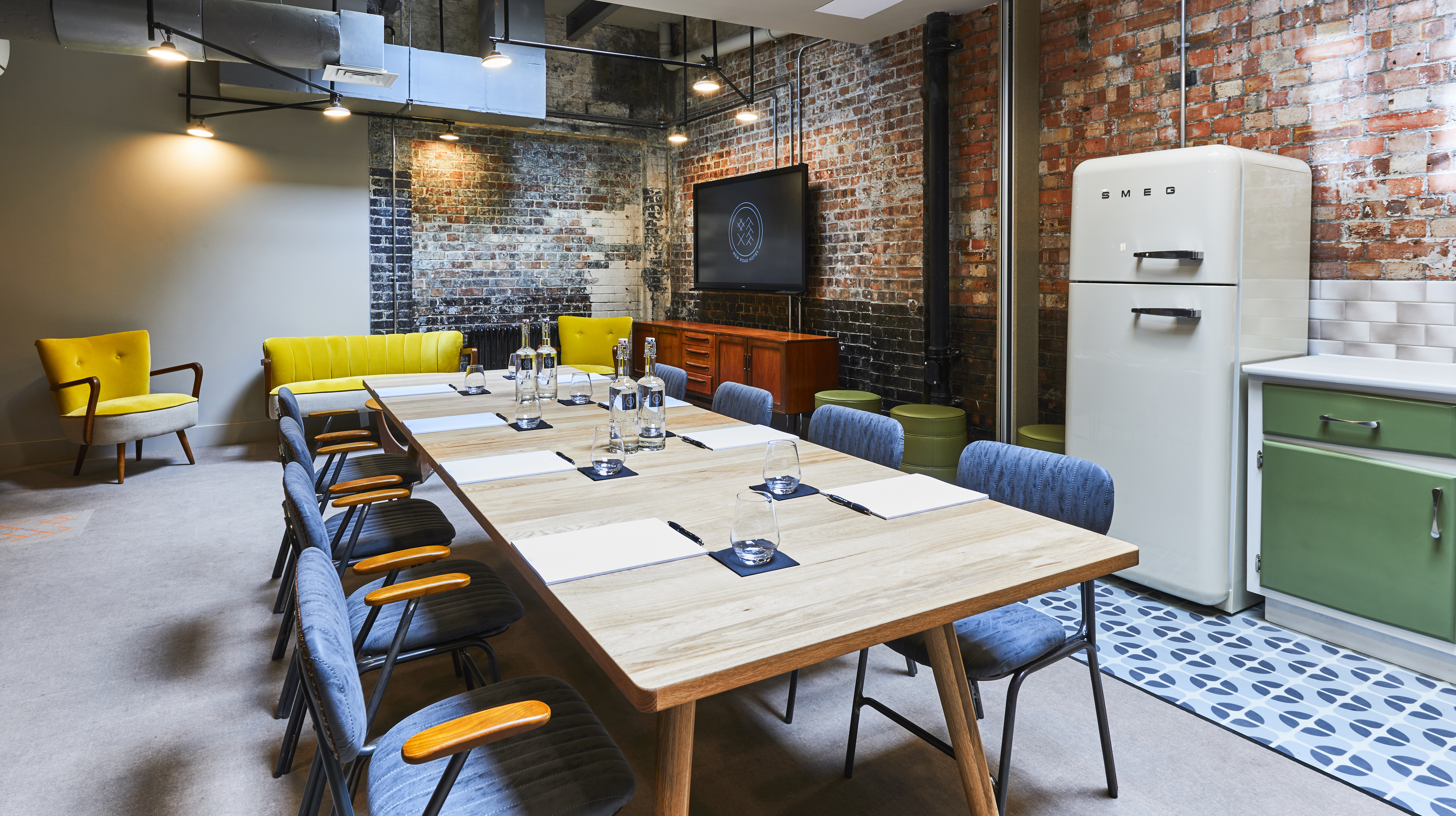 Modern meeting space with wooden table in New Road Hotel for workshops and brainstorming.