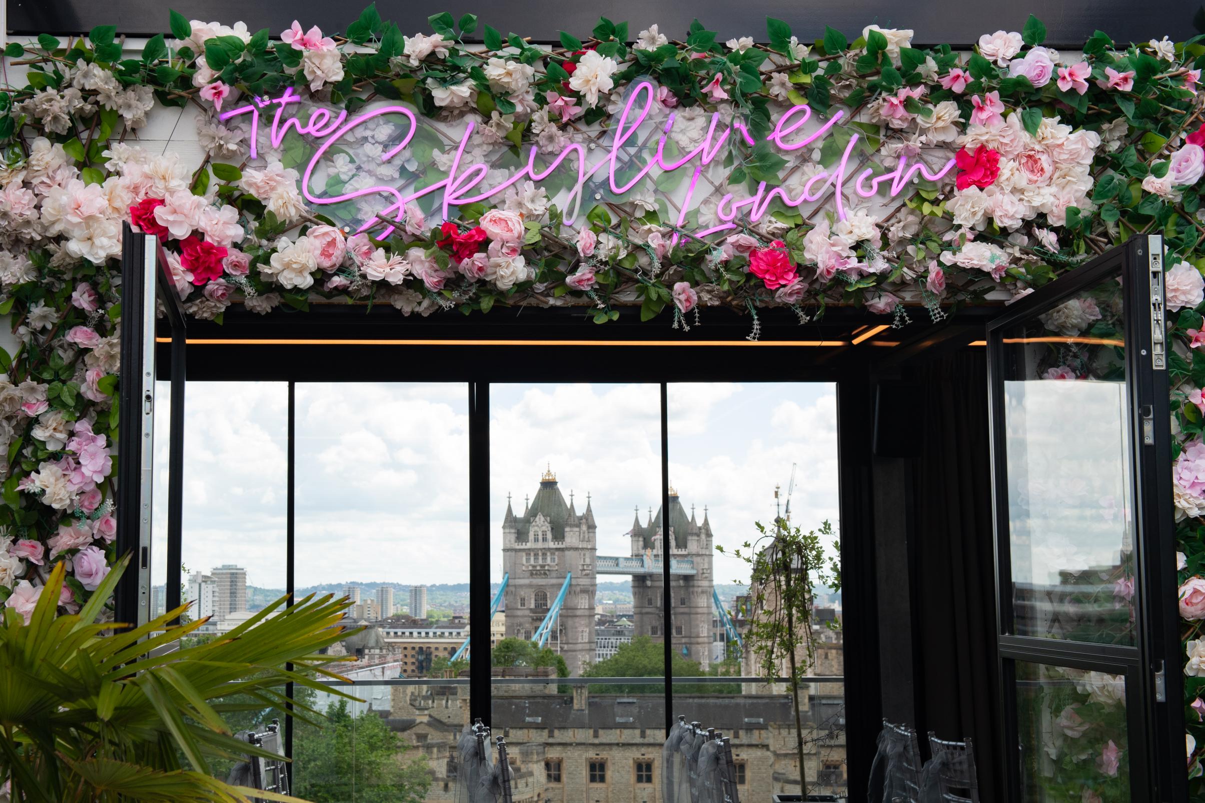 Event space at The Skyline London with floral arch and Tower Bridge view.