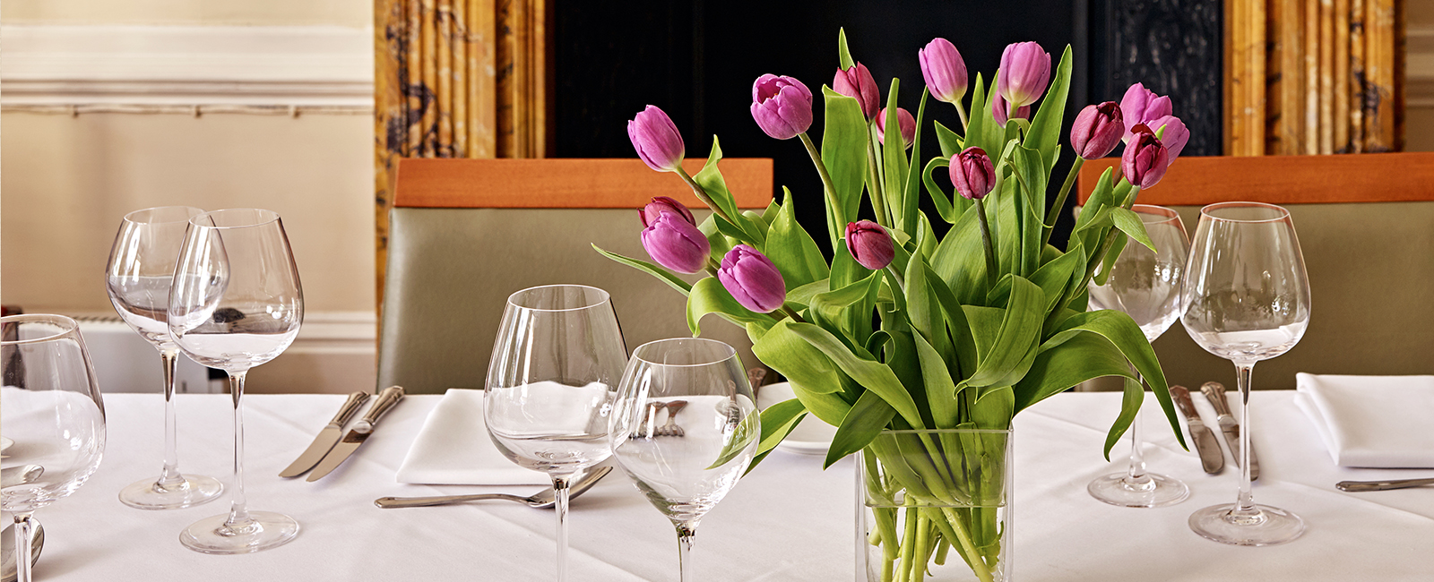Elegant dining table with purple tulips at University Women's Club event.