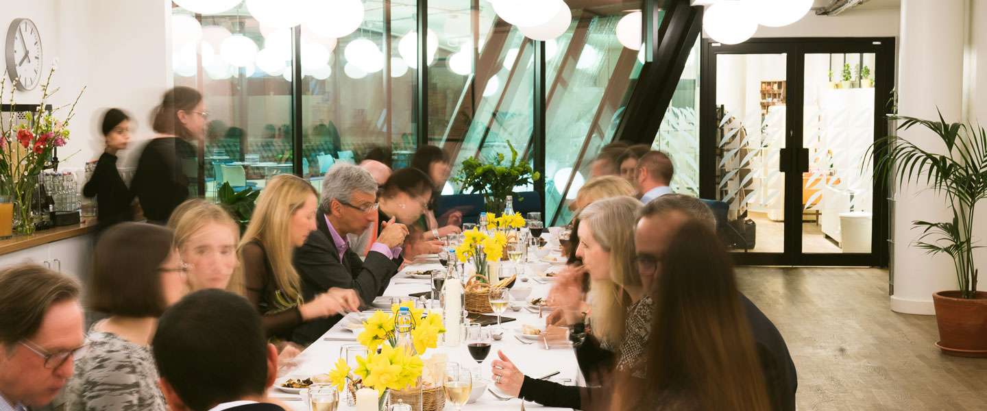 Lively dinner event at Covent Garden Kitchen with guests networking around a floral table.