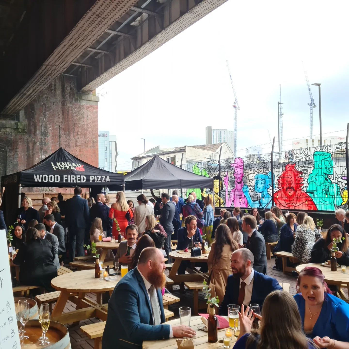 Vibrant outdoor event at Alphabet Brewing Company with casual seating and wood-fired pizza.