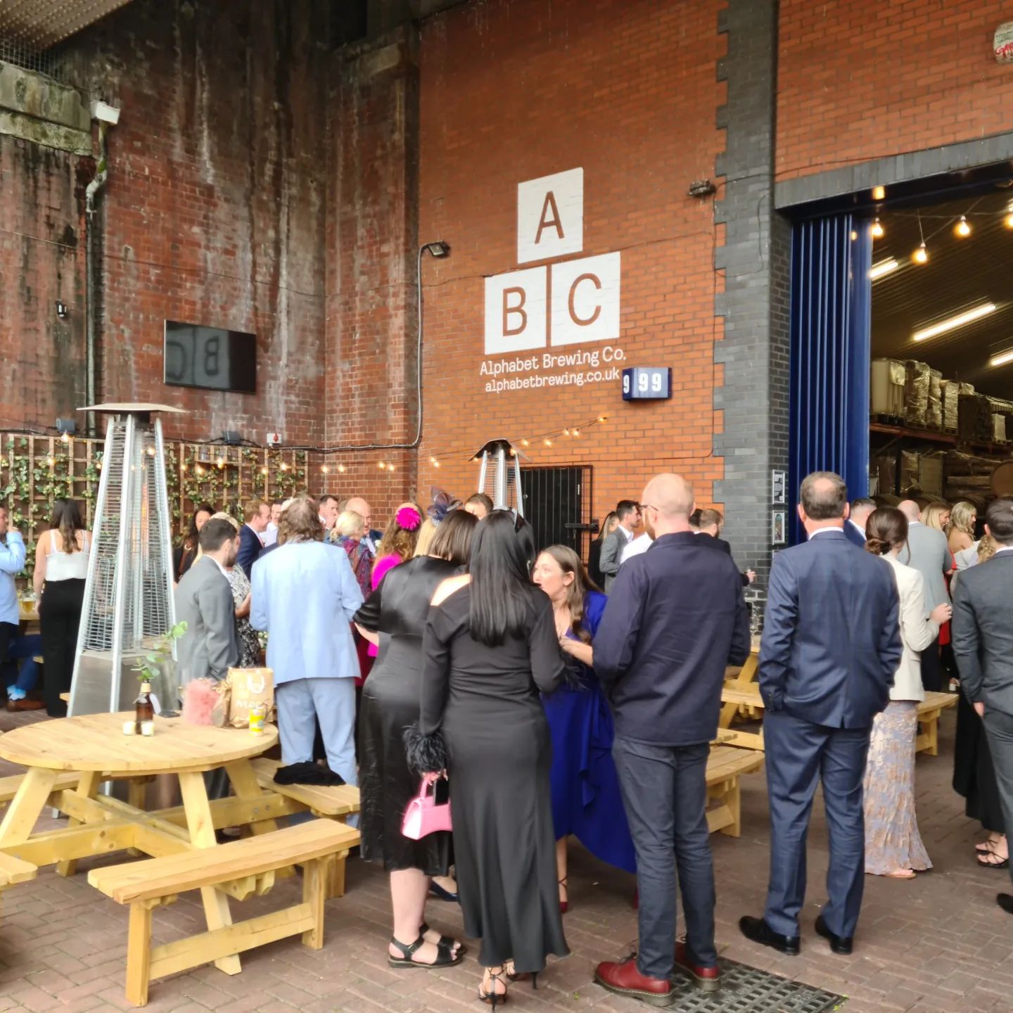 "Vibrant networking event at Alphabet Brewing Company with outdoor seating and industrial charm."