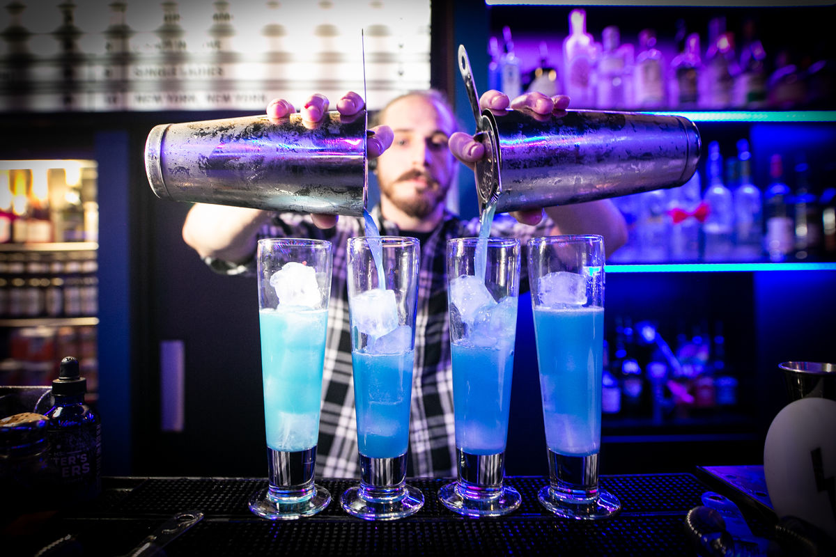 Bartender mixing vibrant cocktails at Lucky Voice Soho event venue.