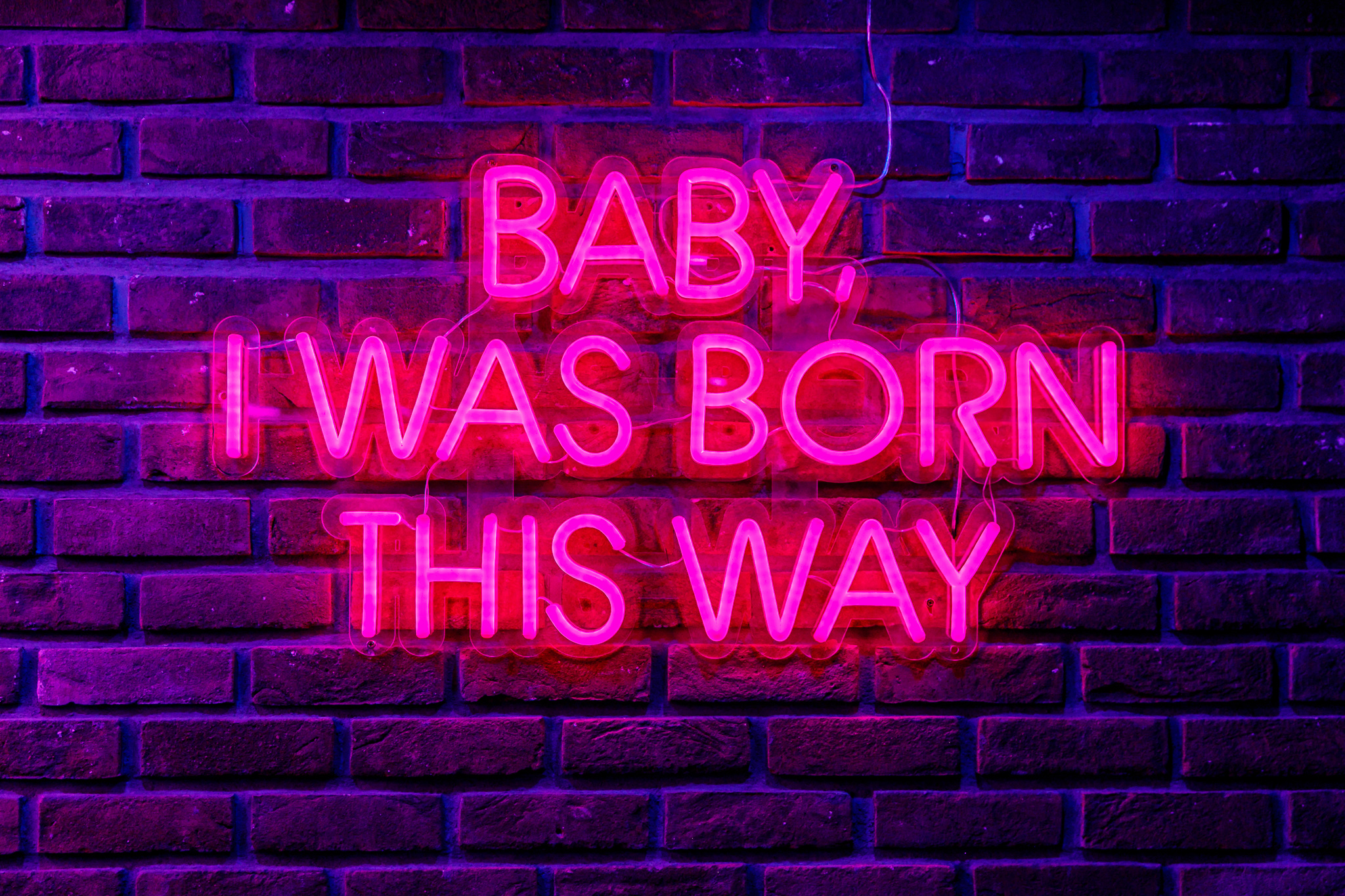 Private karaoke room with neon sign "Baby, I Was Born This Way" for themed events.
