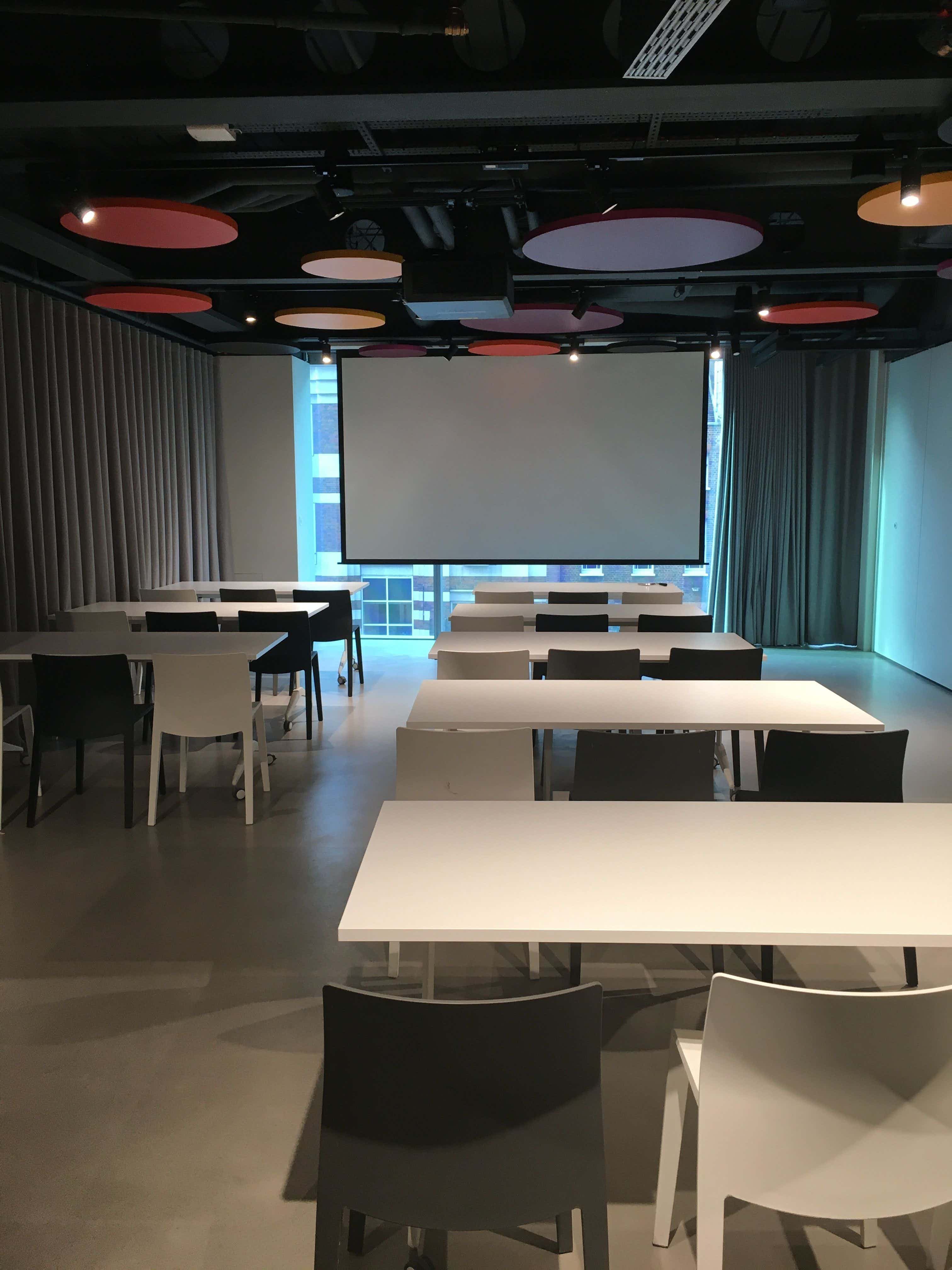 Modern meeting space at HubHub with large screen for presentations and discussions.
