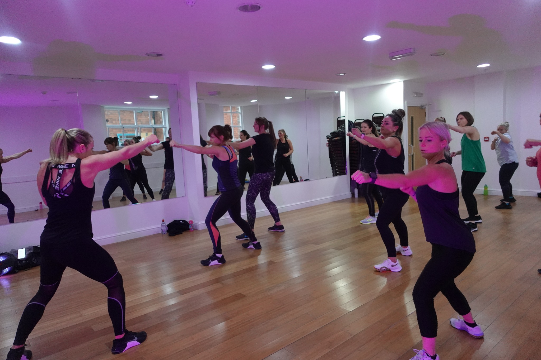 Dynamic group fitness class in a bright studio for wellness events and team-building.