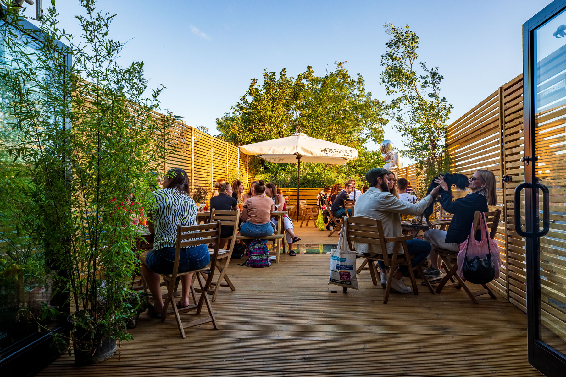 Vibrant TOLA Main Room outdoor event space with wooden deck, ideal for networking gatherings.