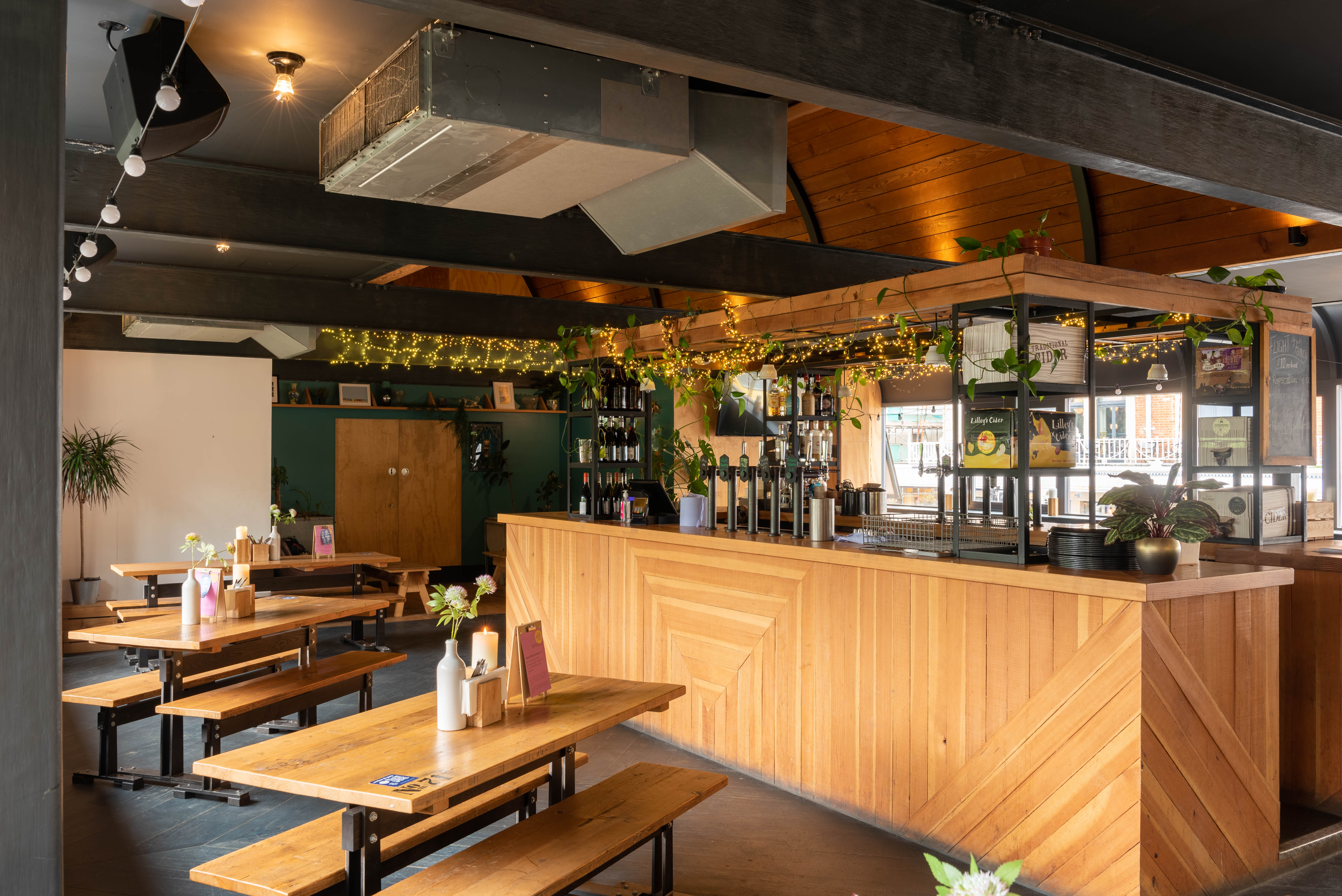 Versatile event space with rustic wooden bar, ideal for gatherings and receptions in Bournemouth.