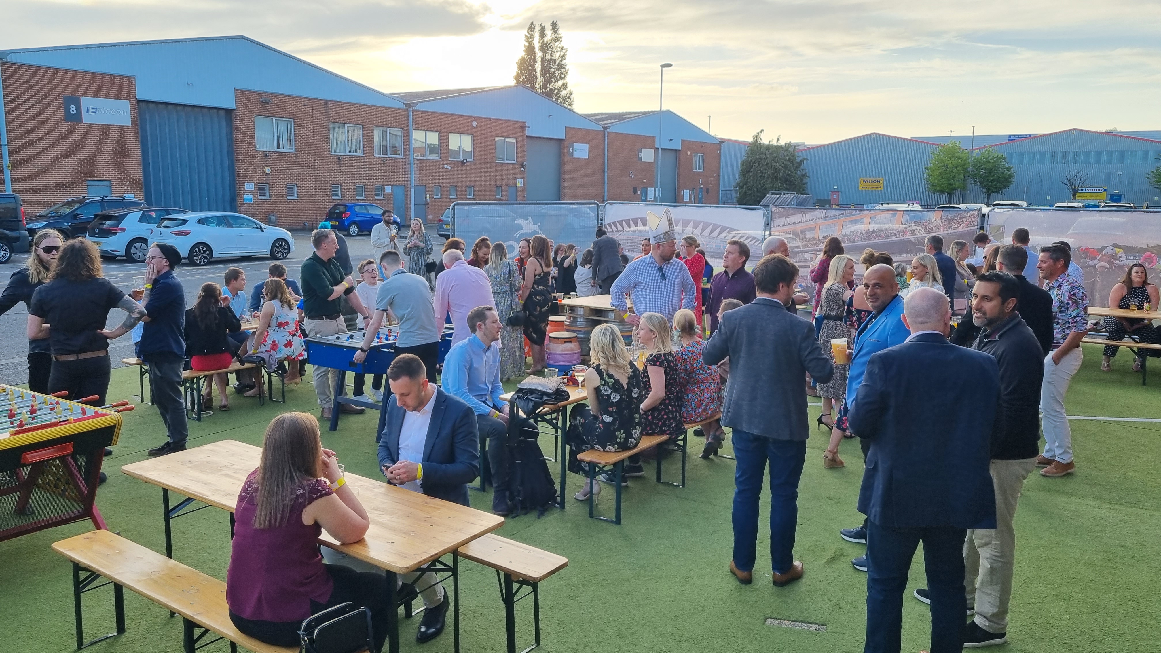 Outdoor networking event at The Mezzanine, featuring communal tables and warm lighting.
