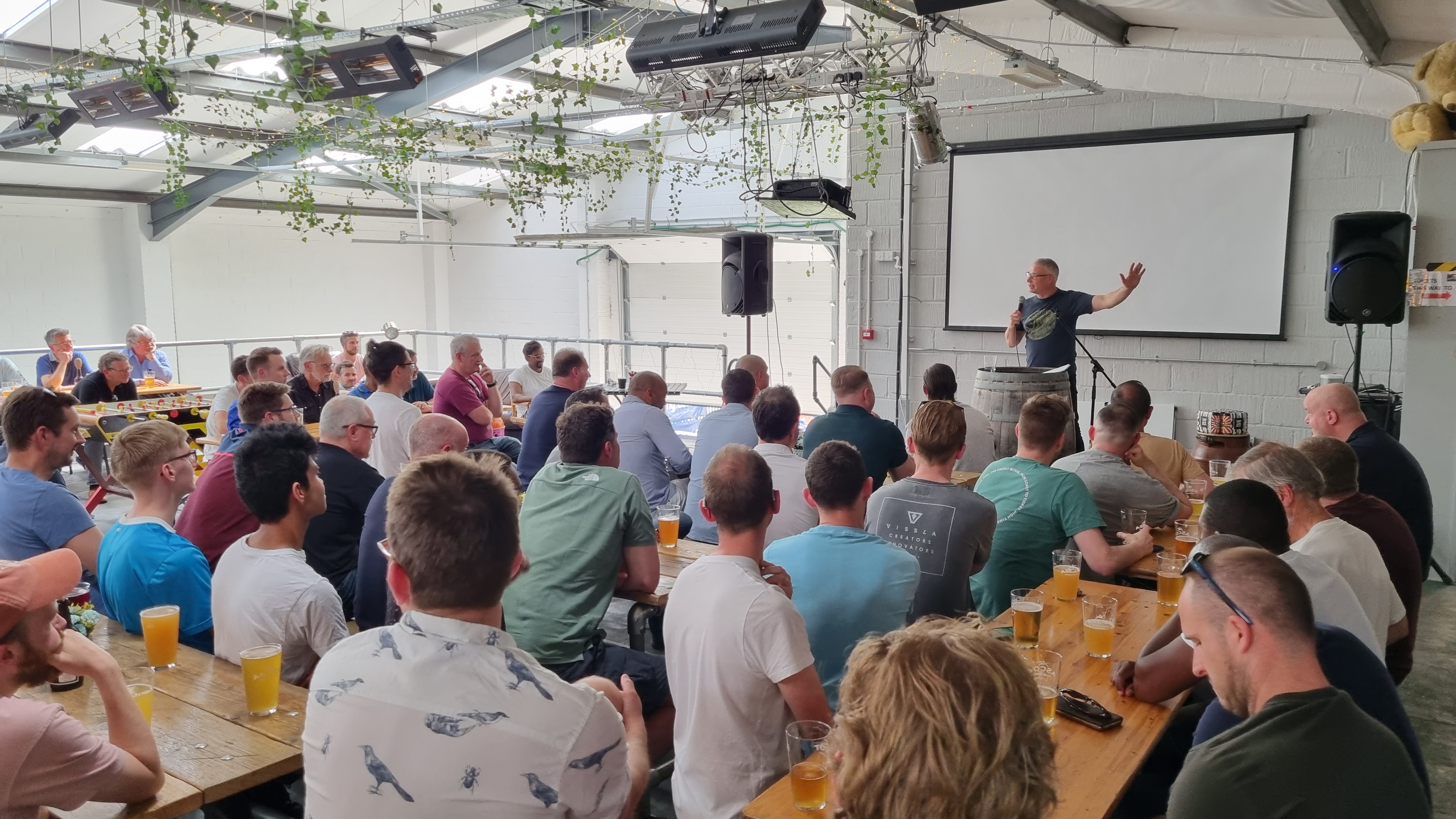 Lively event at The Mezzanine, featuring a speaker and networking setup in a brewery.