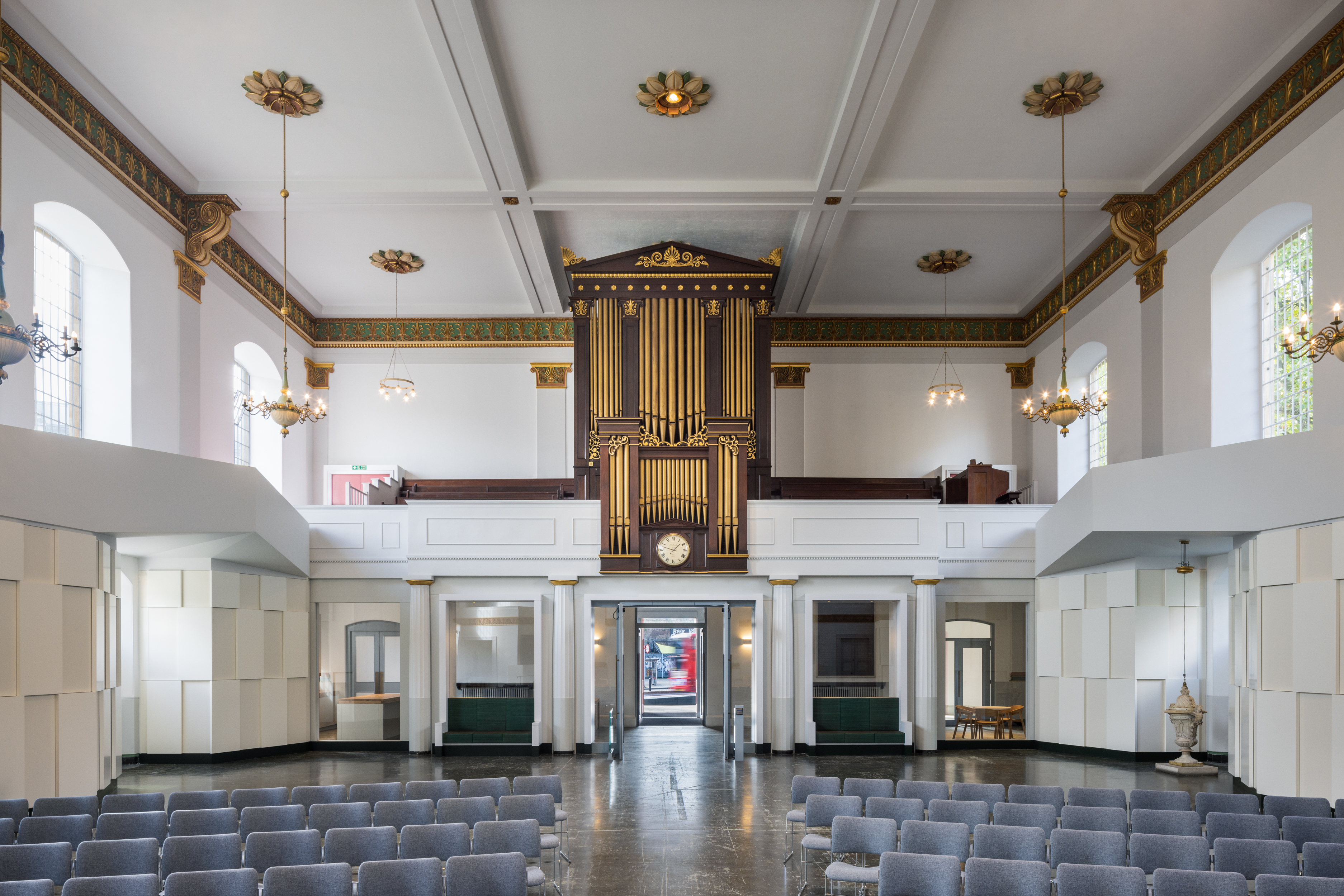 Elegant event venue with high ceilings and organ, perfect for ceremonies and performances.