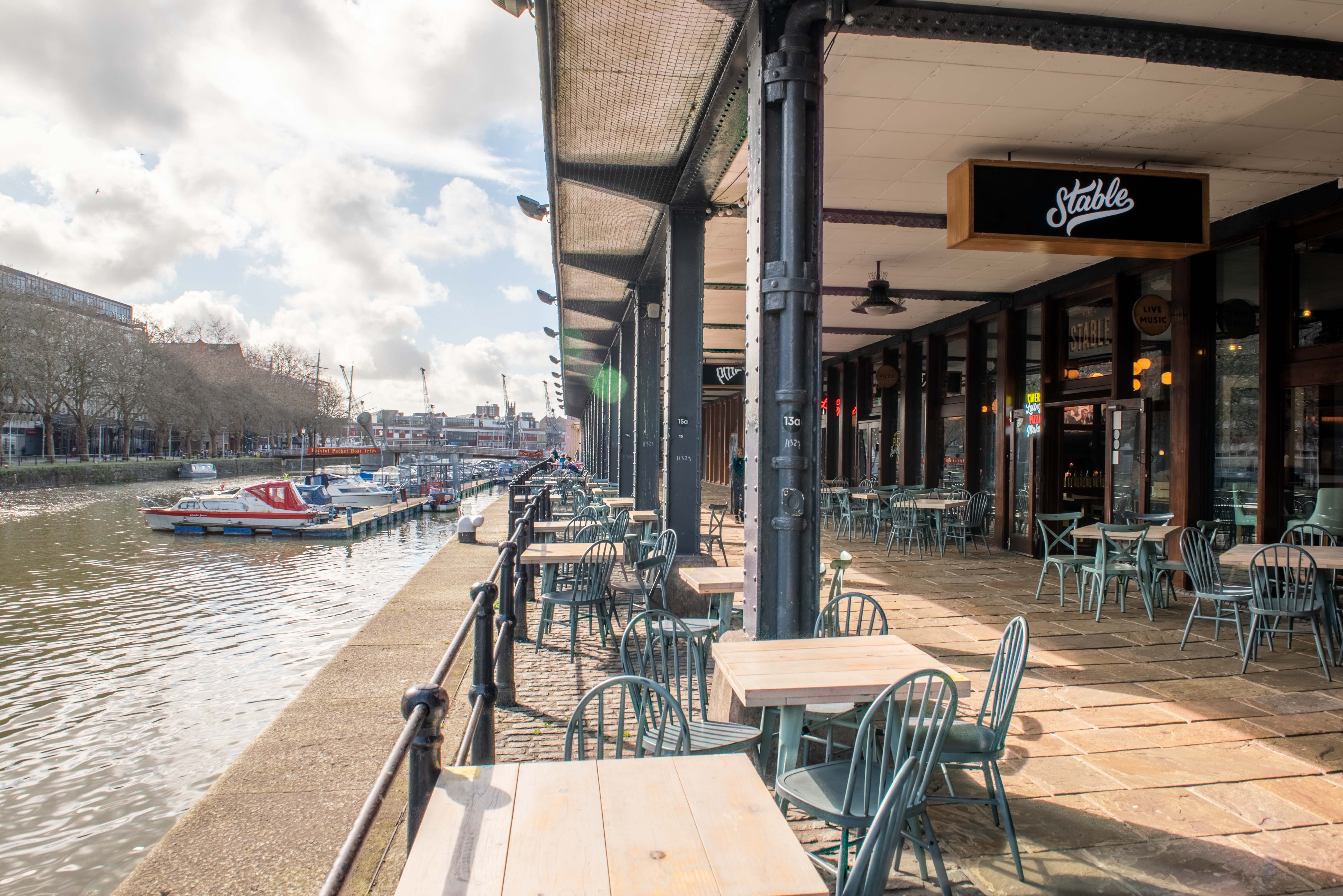 Charming waterfront venue with outdoor seating for casual meetings and networking events.
