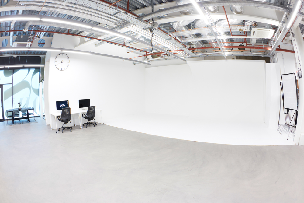 Versatile minimalist event space with clean backdrop for meetings and workshops.