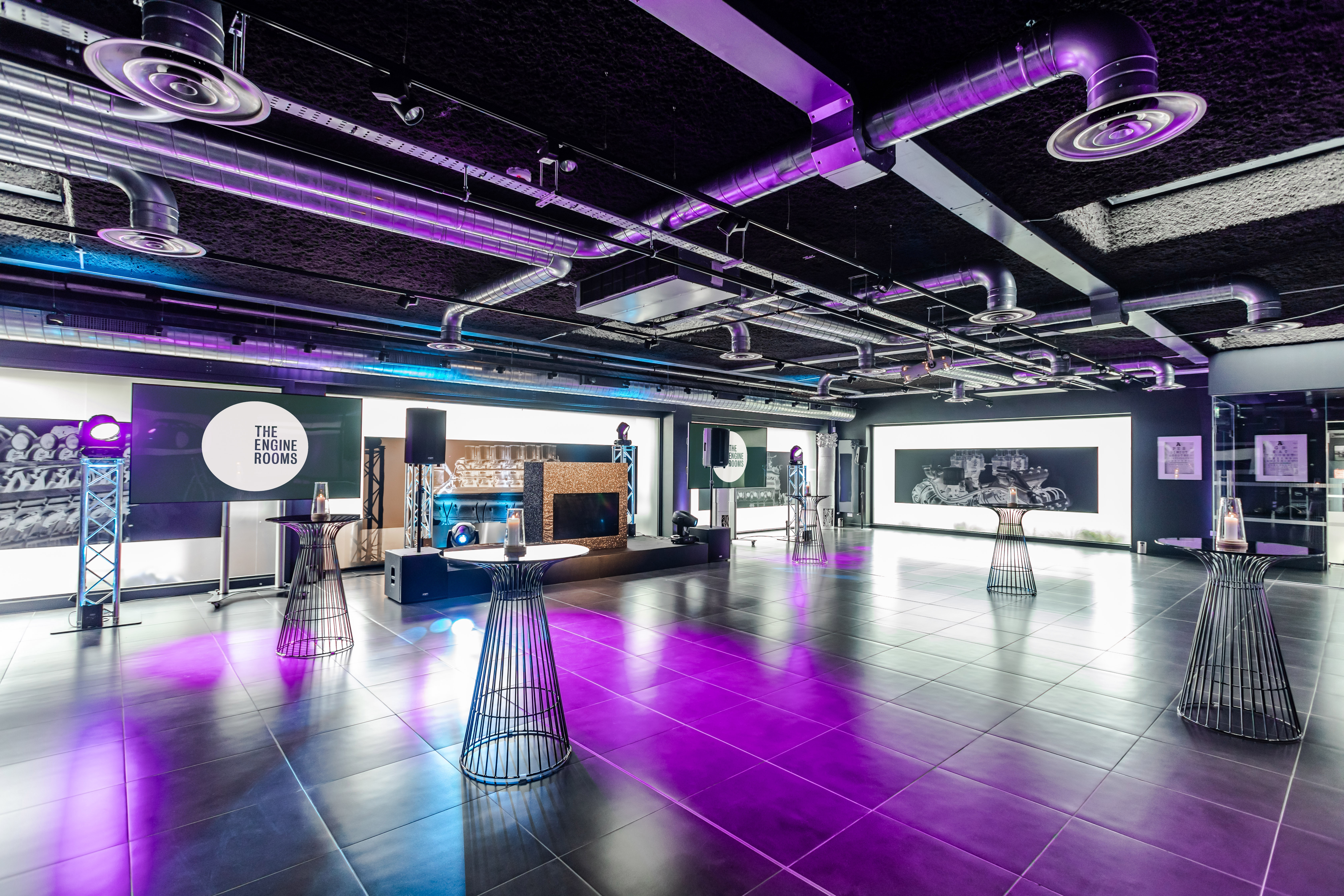 Modern industrial event space with ambient lighting for corporate gatherings.