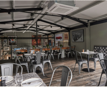 Modern industrial event space with natural light, ideal for gatherings and meetings.