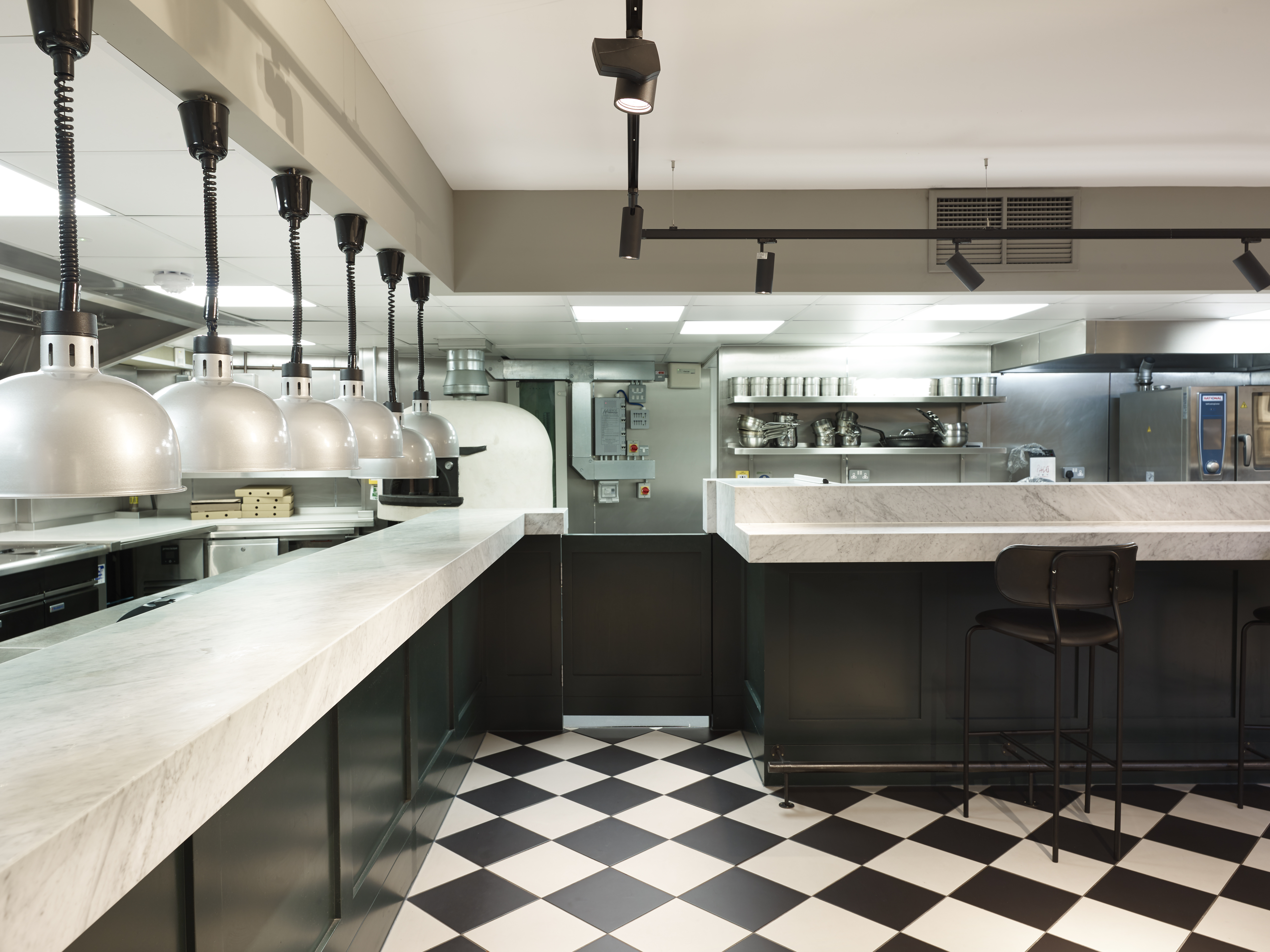 Modern kitchen with marble countertops for high-end catering events and cooking classes.