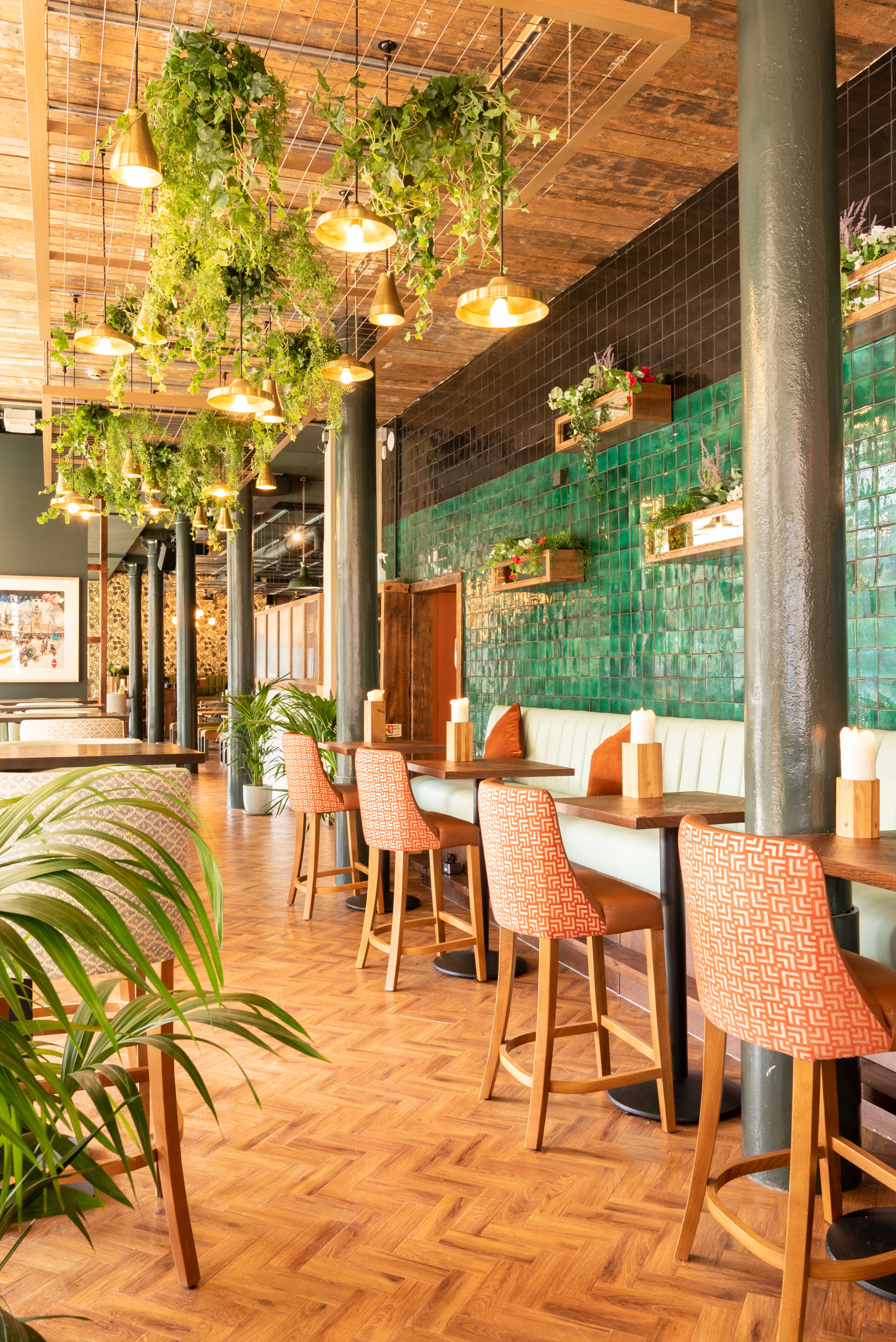 Stylish event venue with vibrant green tiles and cozy seating for meetings and gatherings.