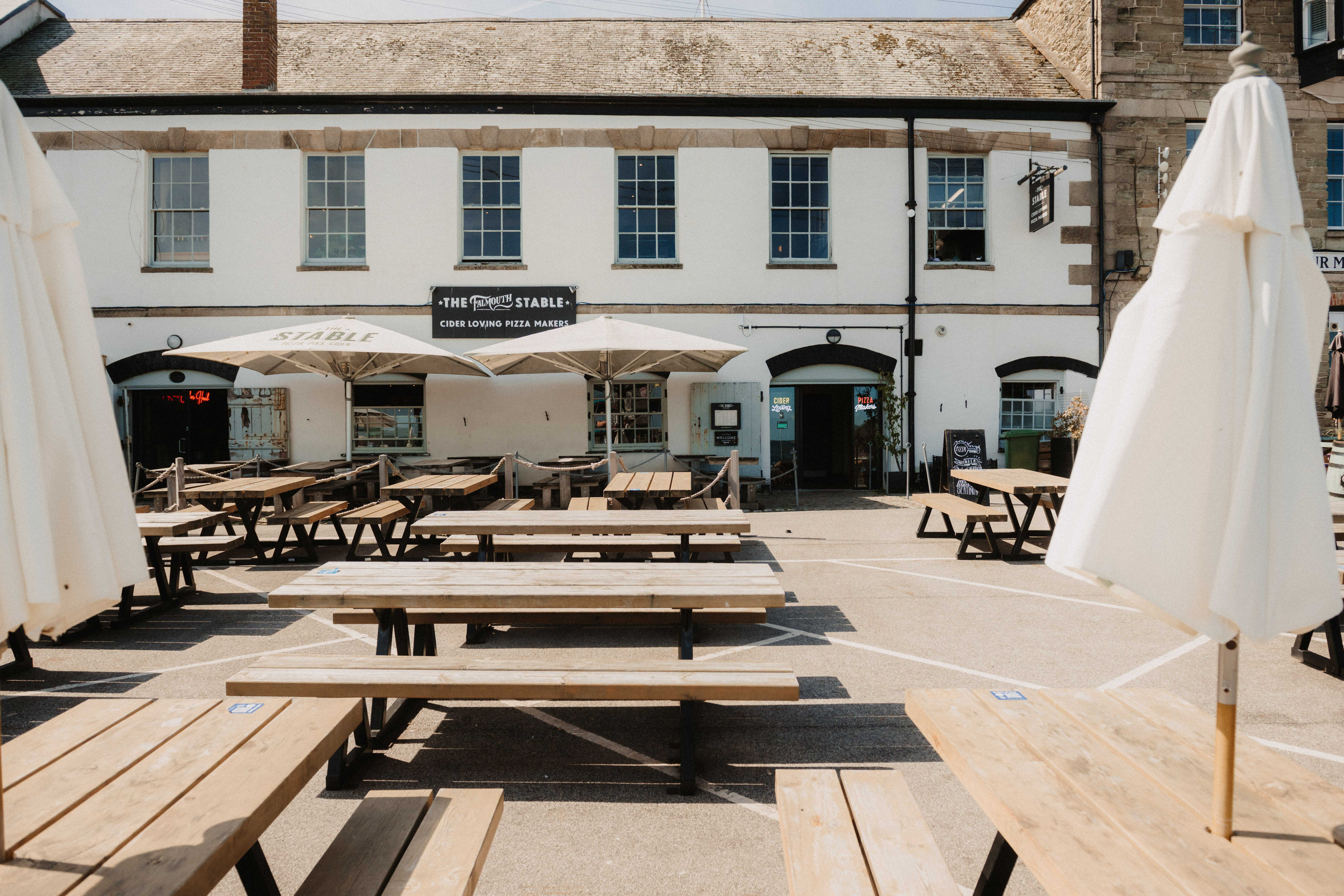 Outdoor event space with wooden picnic tables for summer parties and networking.