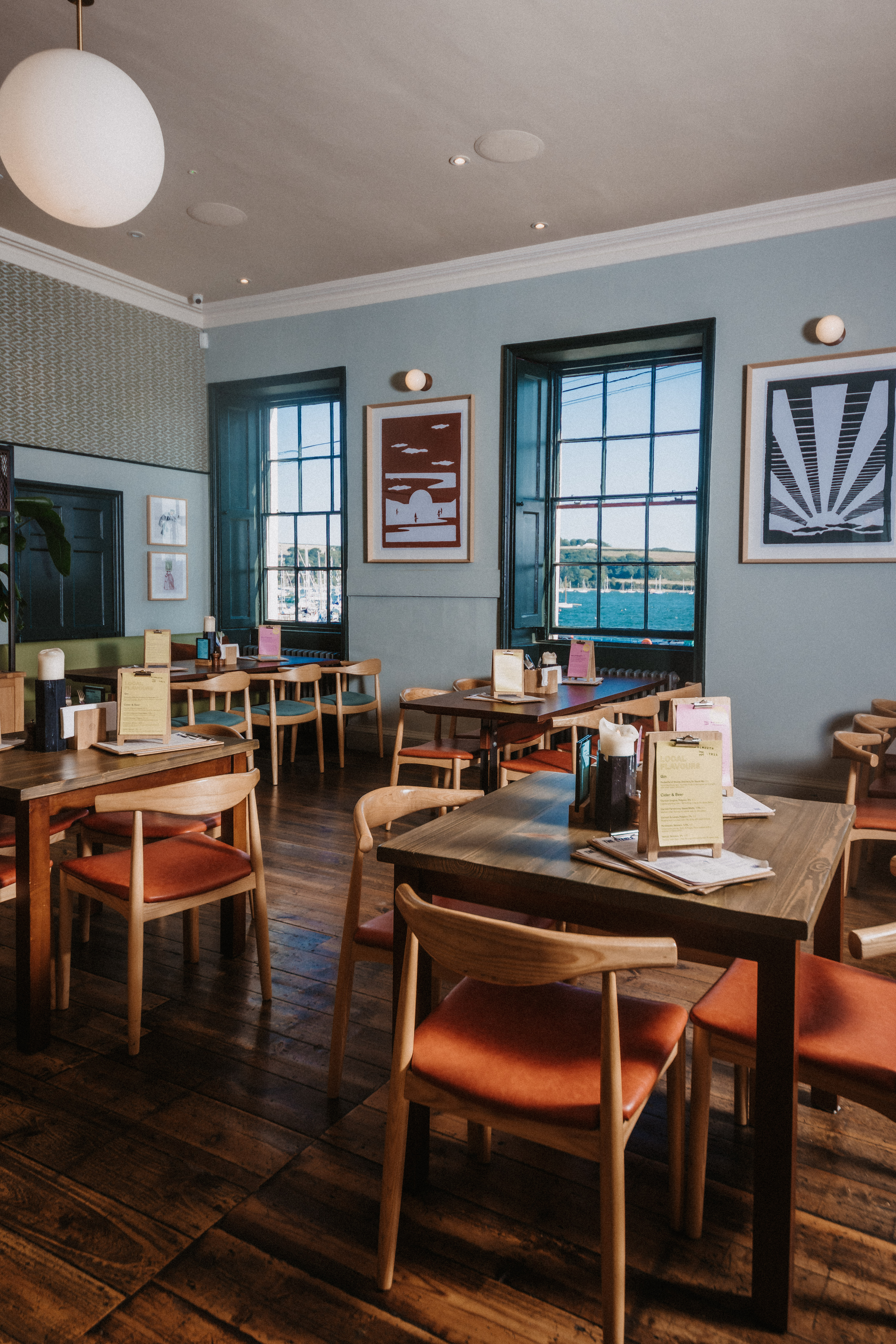 Modern event space with wooden tables and natural light for meetings or gatherings.