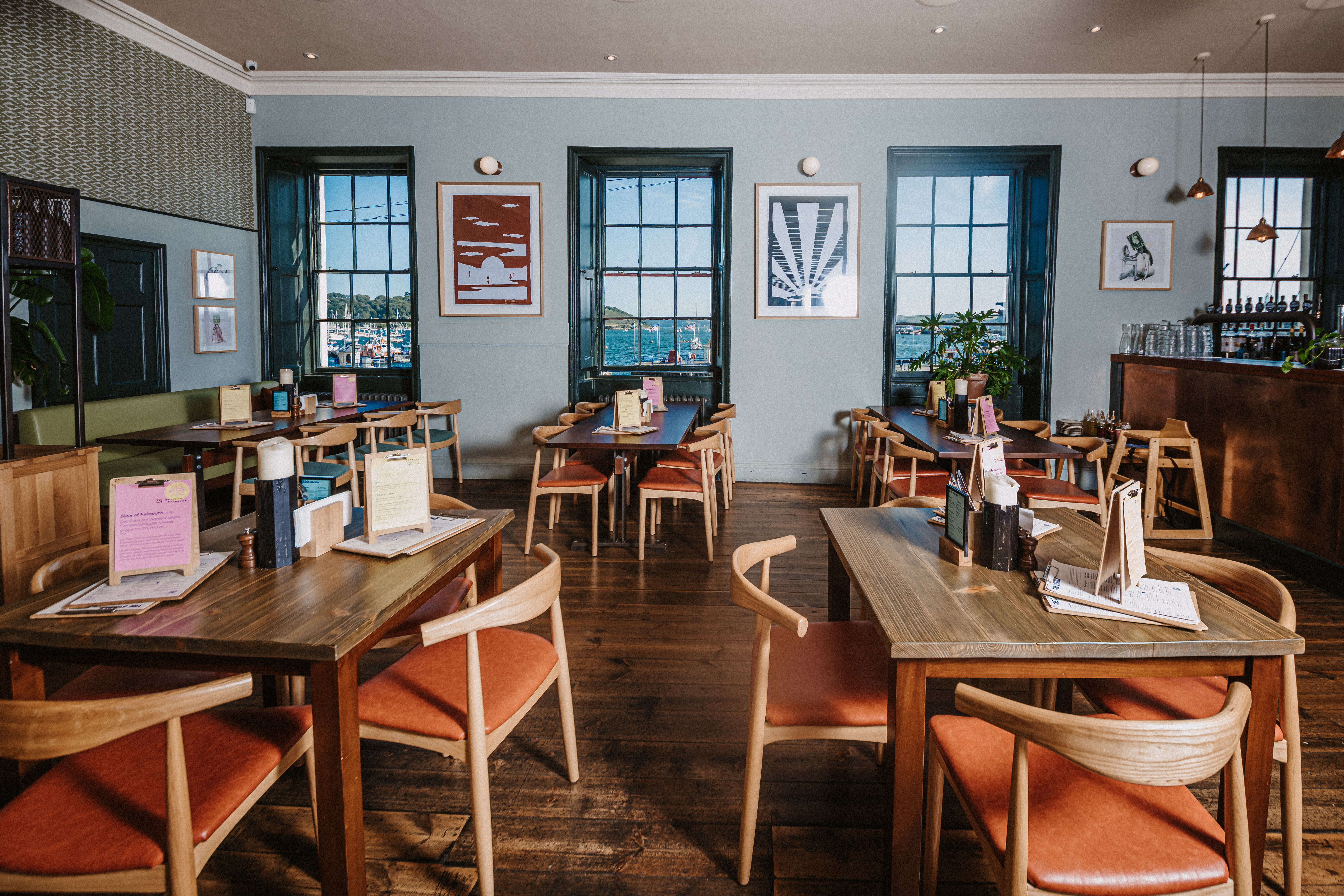 Modern dining space with wooden tables for events and meetings at The Falmouth Stable.