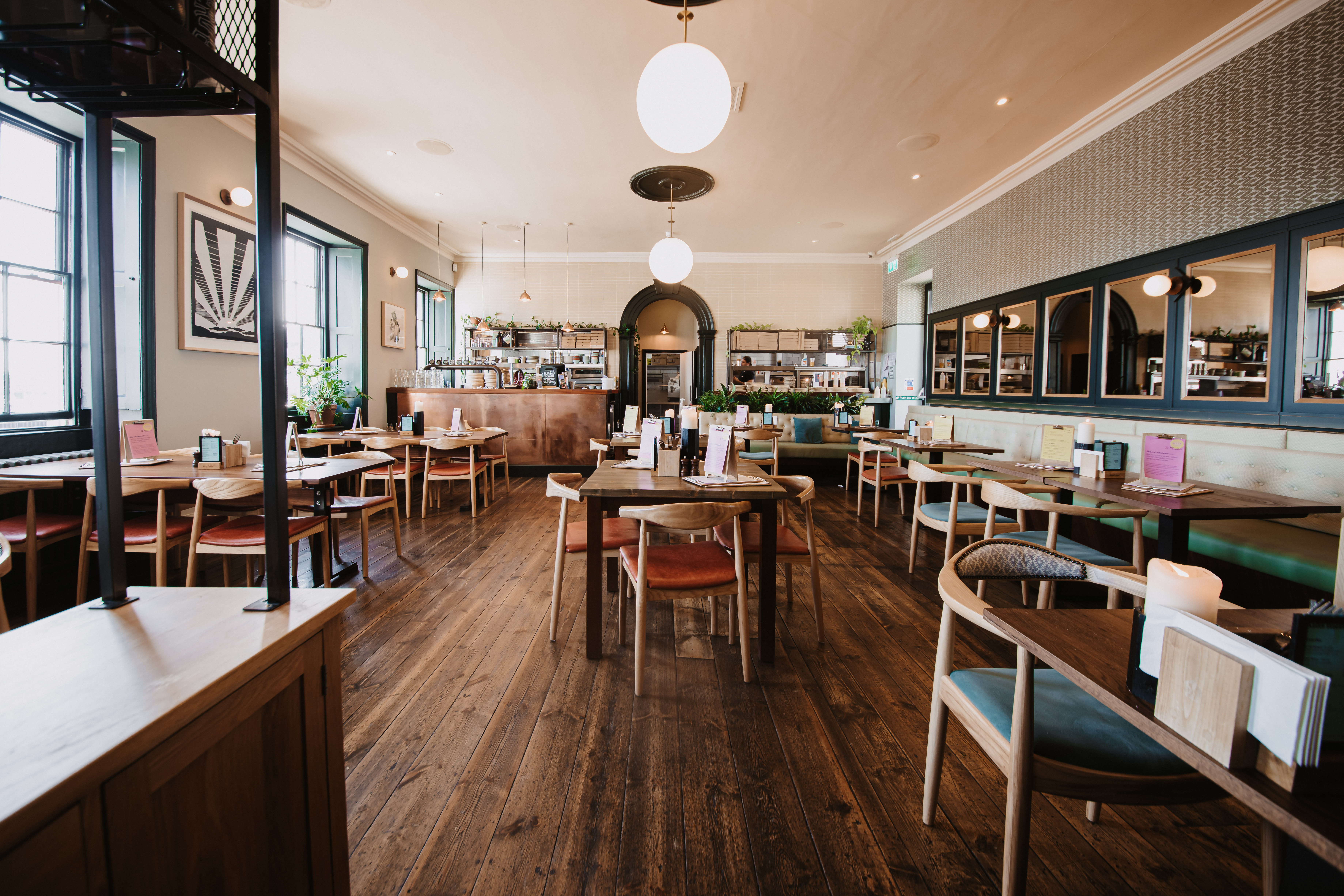 Intimate restaurant space with warm wood flooring, ideal for networking events and meetings.