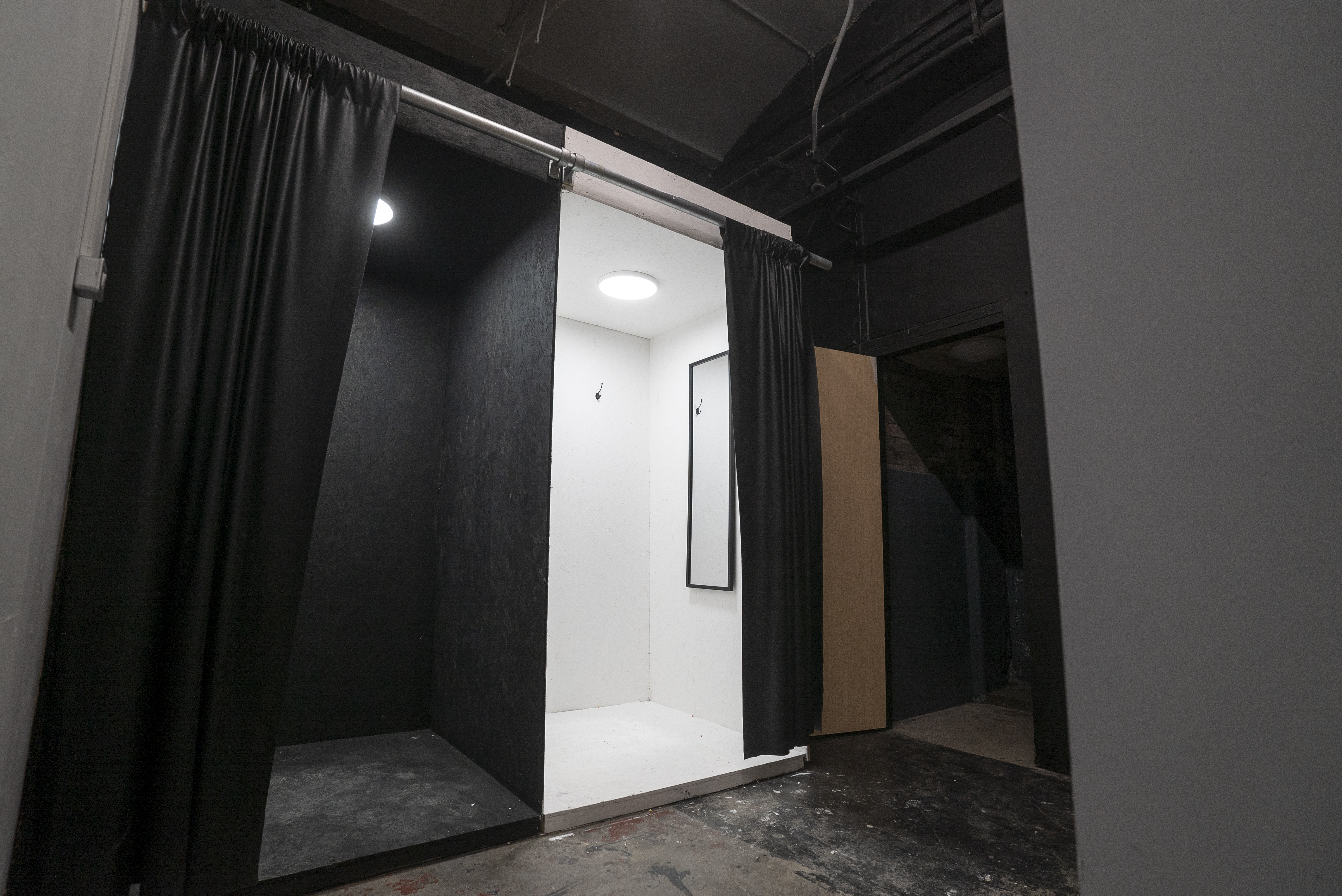 Minimalist XL STUDIO with white interior and black curtains for private meetings.
