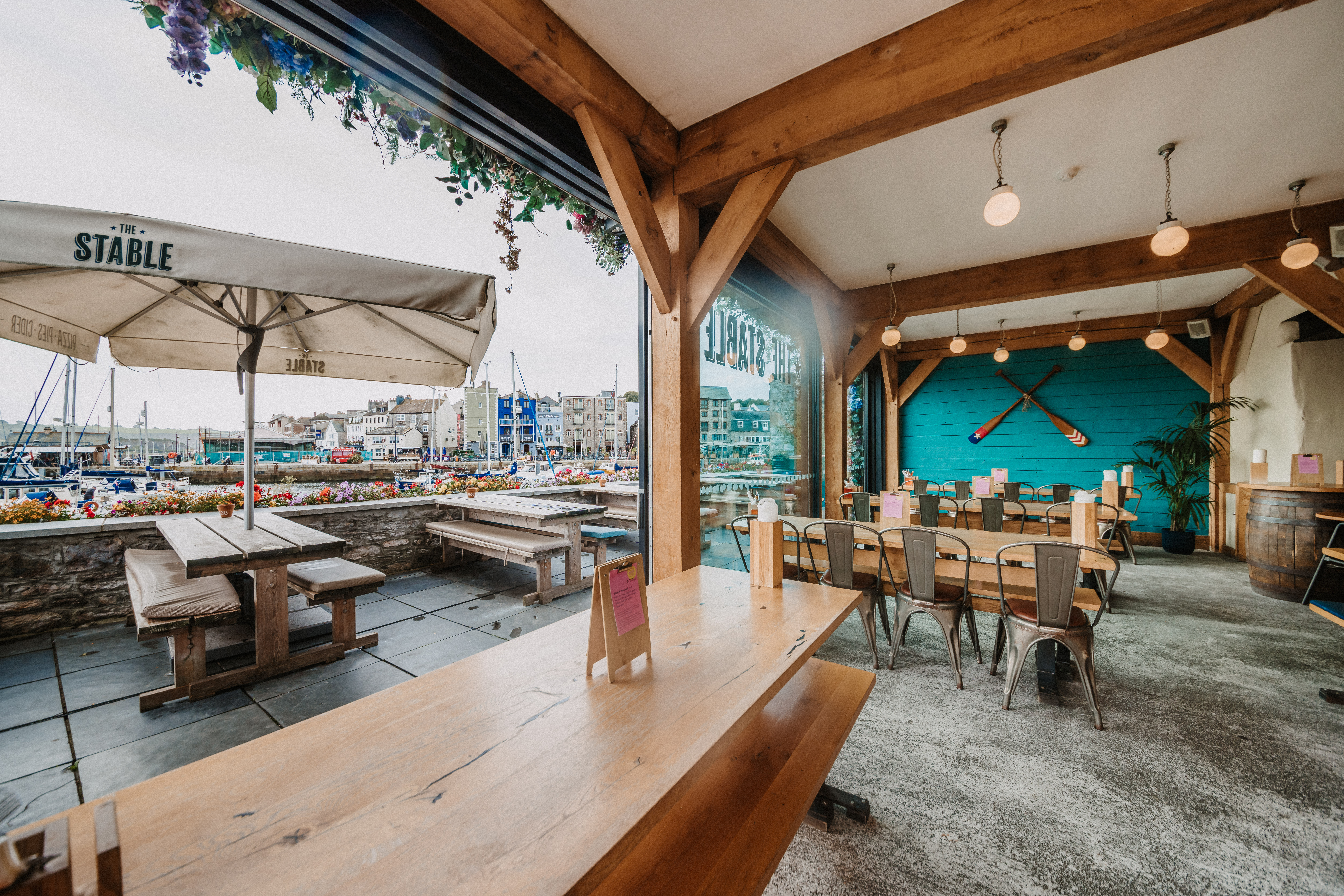 Vibrant waterfront venue with rustic tables for casual meetings and events in Plymouth.