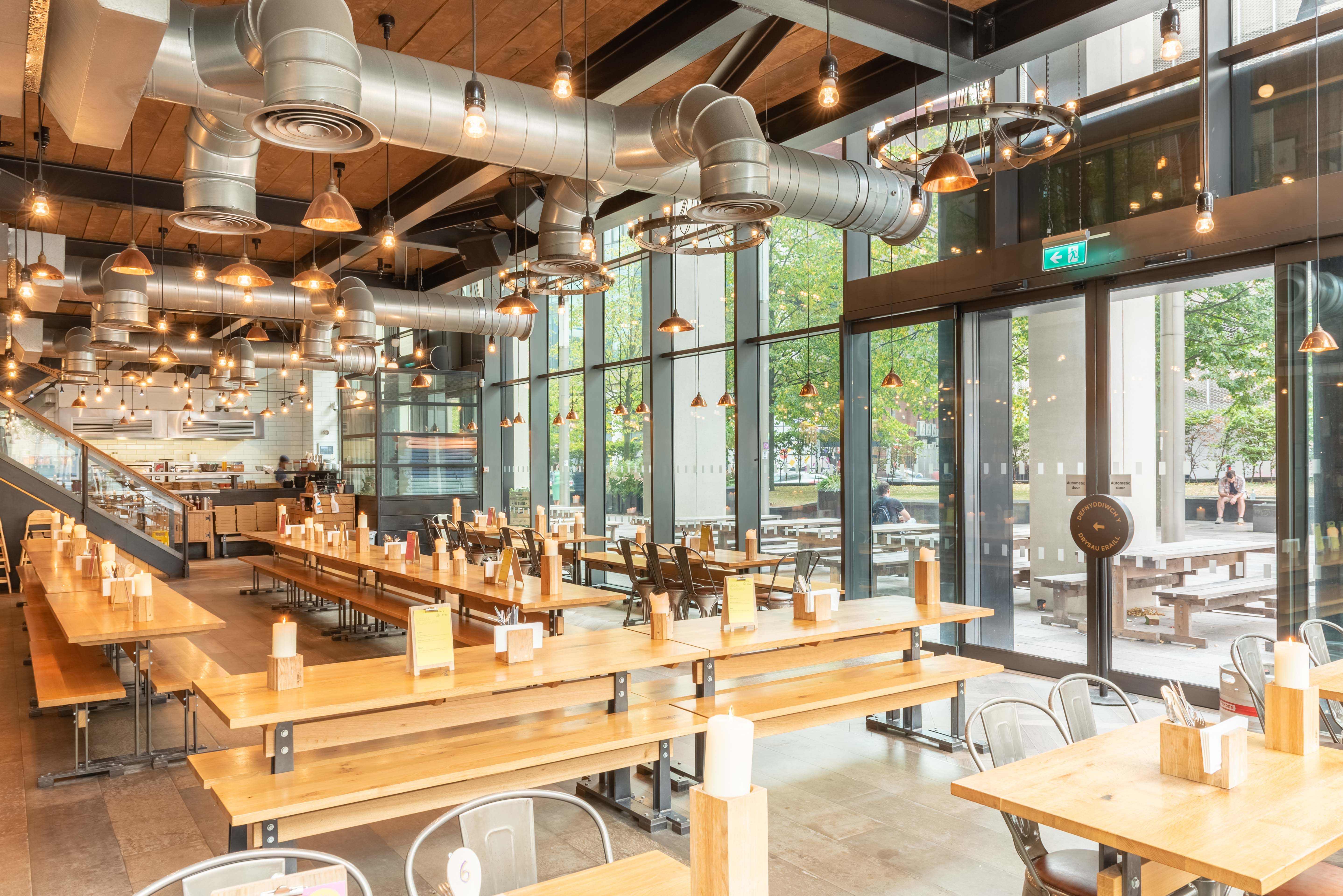 Spacious modern venue with communal tables for casual meetings and networking events.