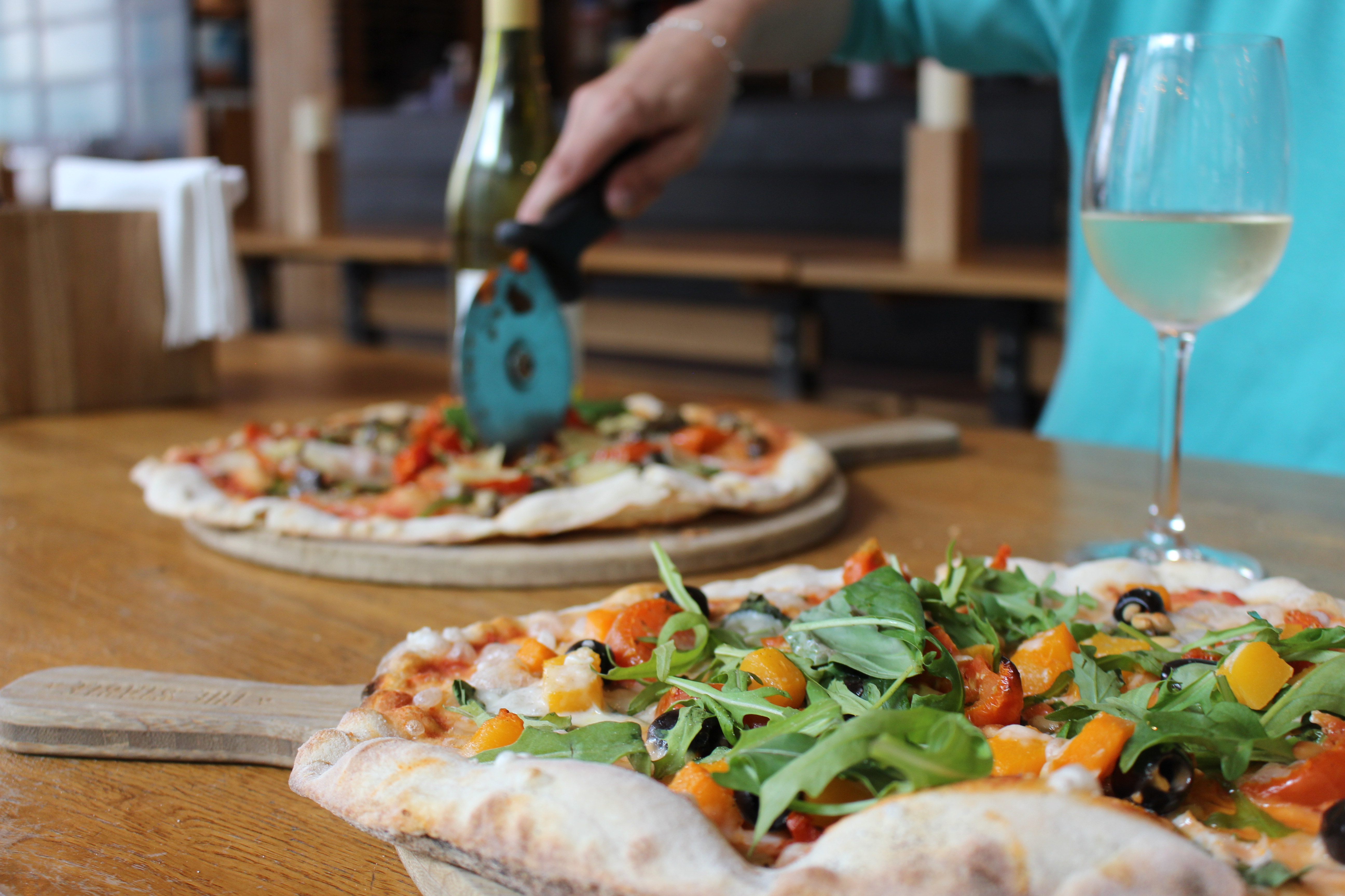 Vibrant dining setup with pizzas for casual networking at The Cardiff Stable.