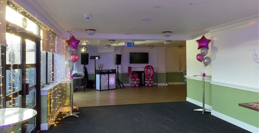 Stylish Par 3 Lounge event space with DJ booth, pink and silver balloon decor.