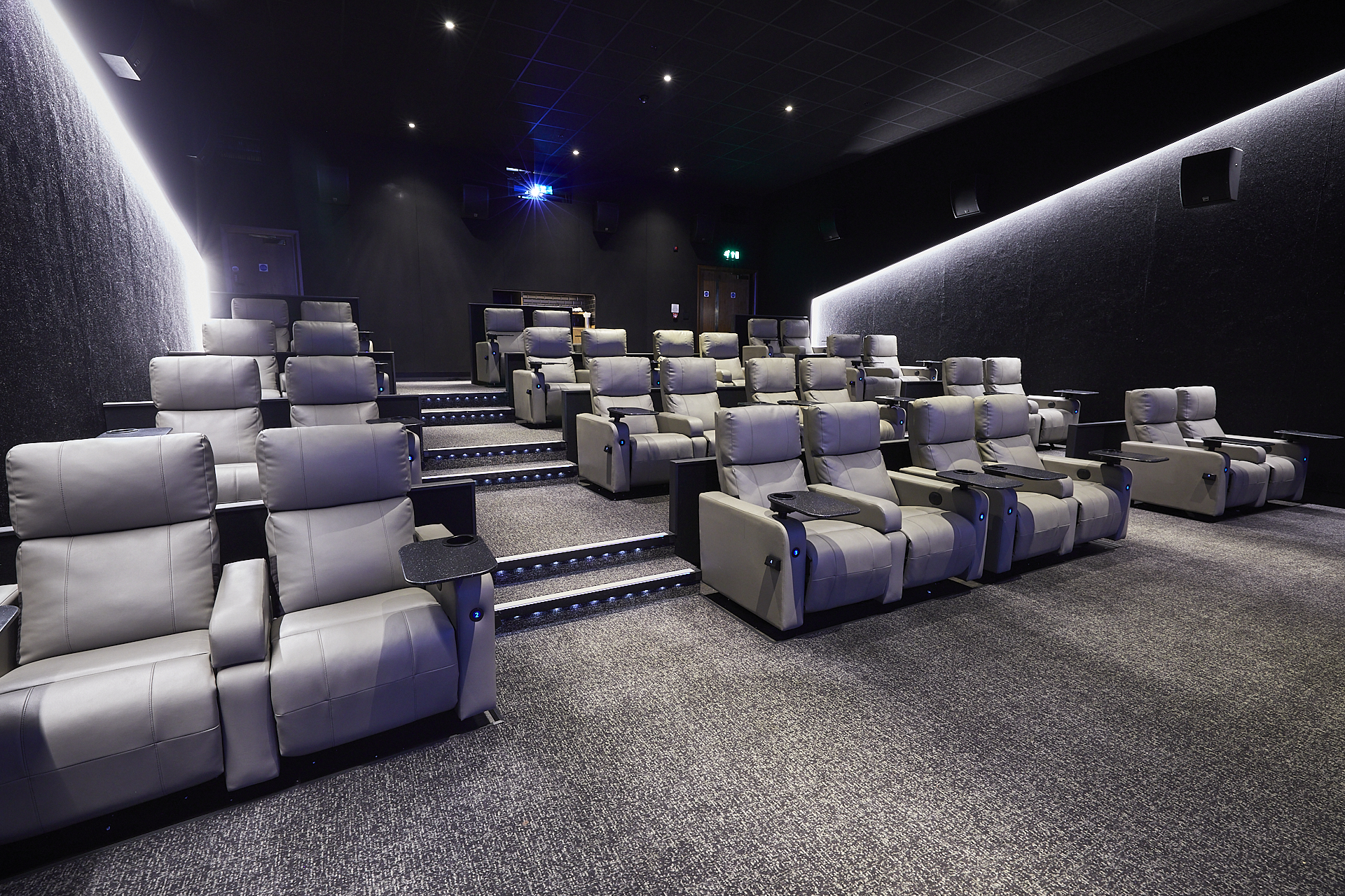 Modern screening room with plush reclining seats for film screenings and corporate events.