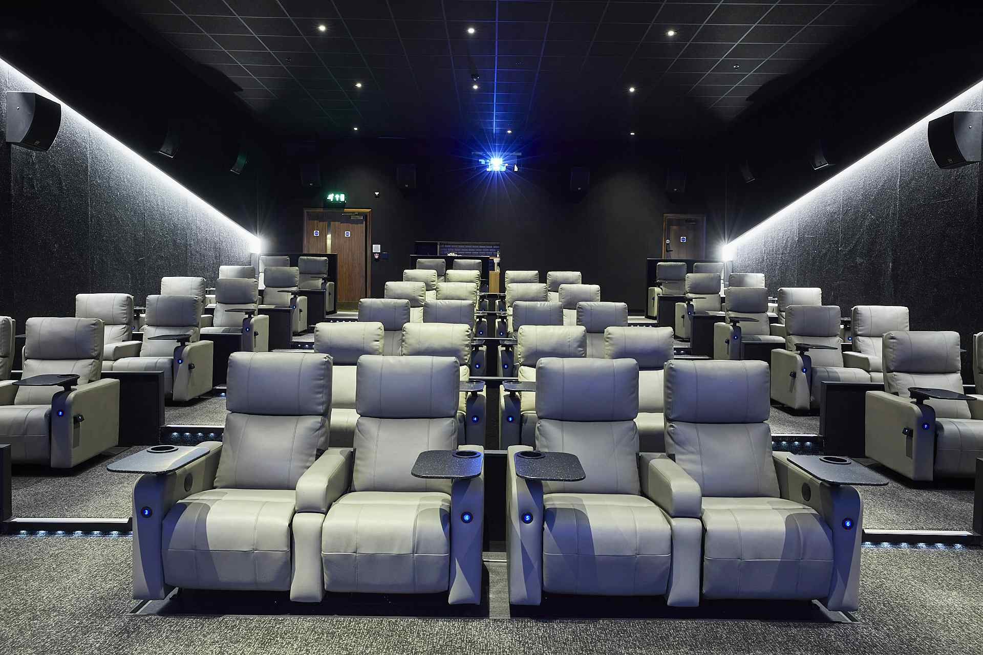 Modern cinema auditorium with plush reclining seats for corporate events and film screenings.