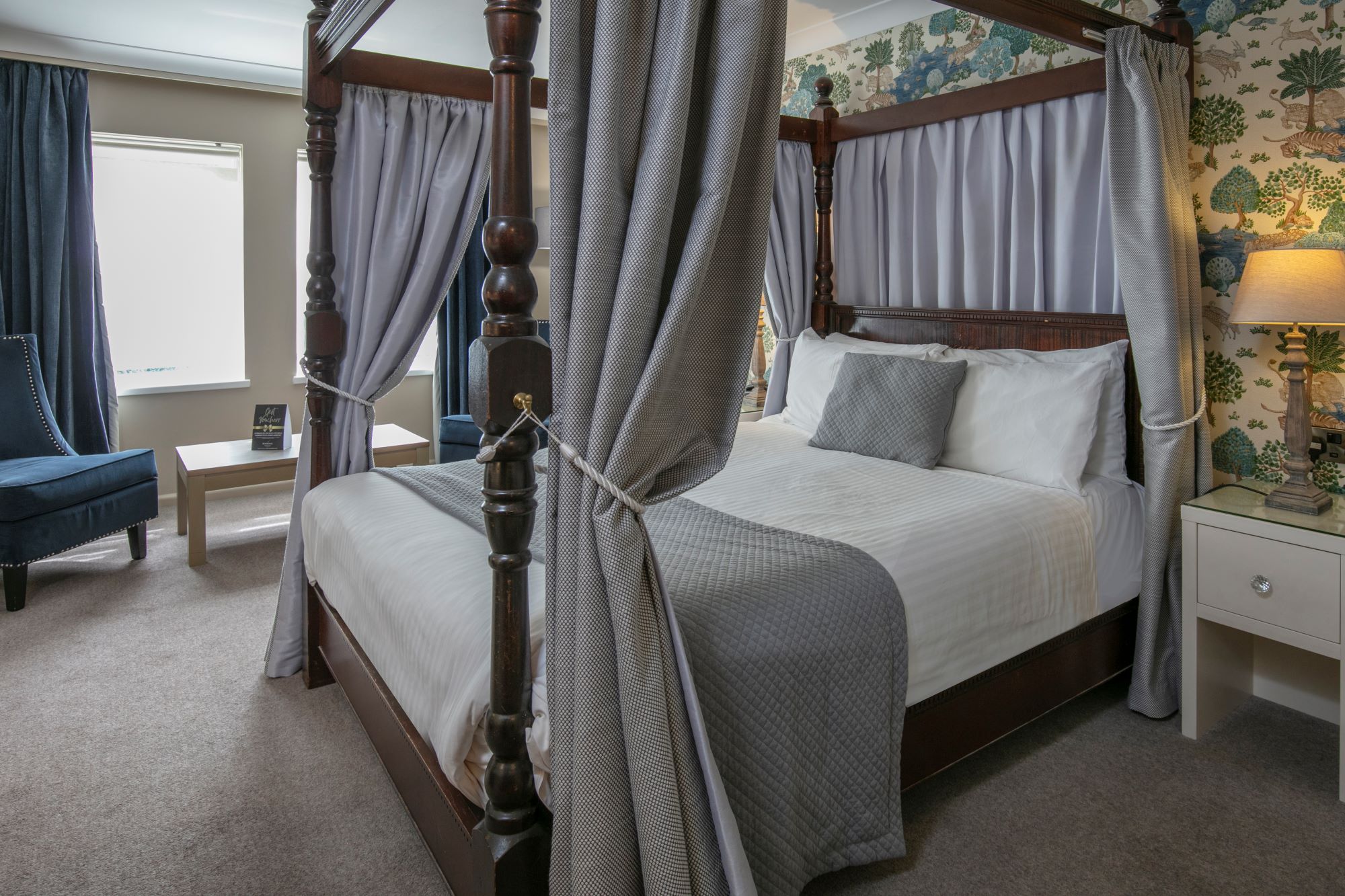Elegant four-poster bed in Charter Suite, Moor Hall Hotel for business events and relaxation.