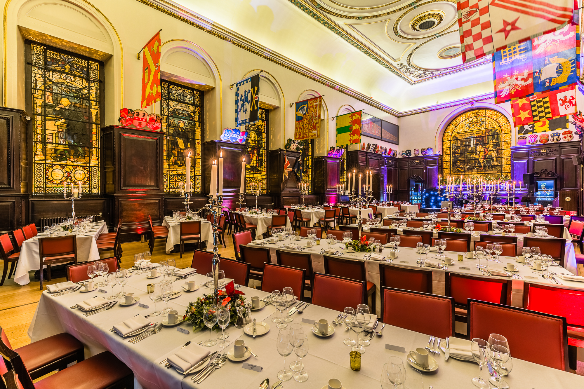 Christmas banquet at Stationers' Hall with elegant table settings and stained glass windows.