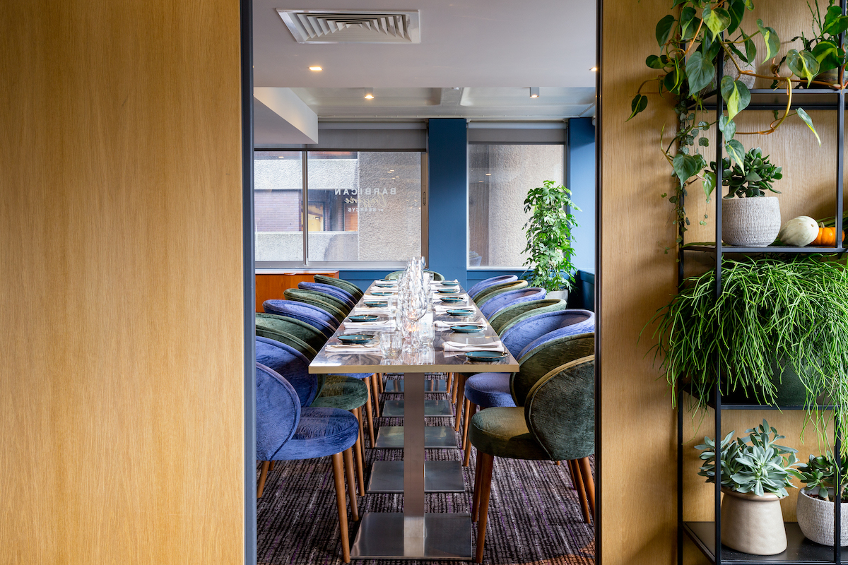 Private dining room with elegant table and colorful chairs for meetings or events.
