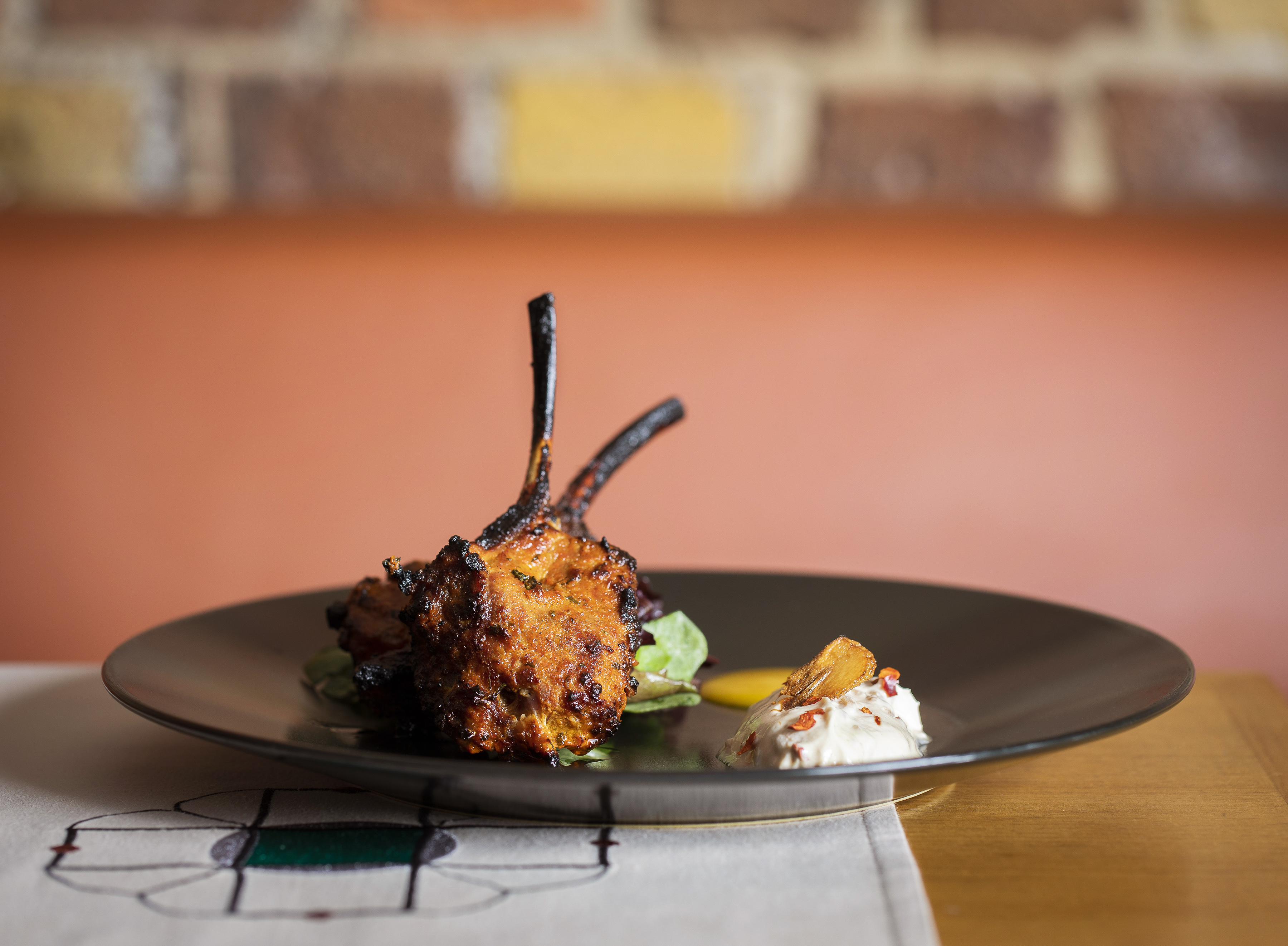 Grilled lamb chops elegantly plated at Babur's Marquee for events and weddings.