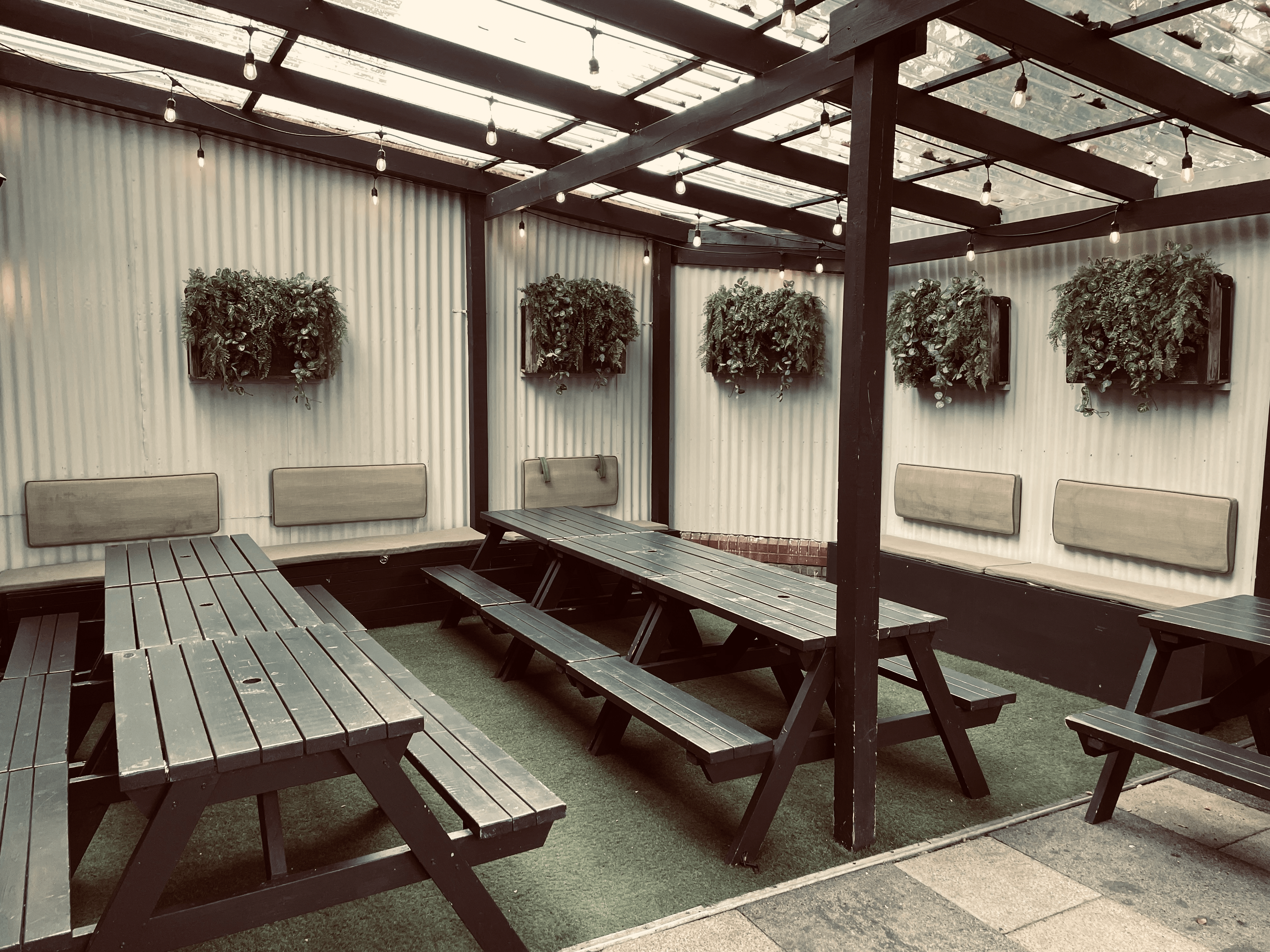 Versatile outdoor event space with rustic benches and greenery for casual meetings.