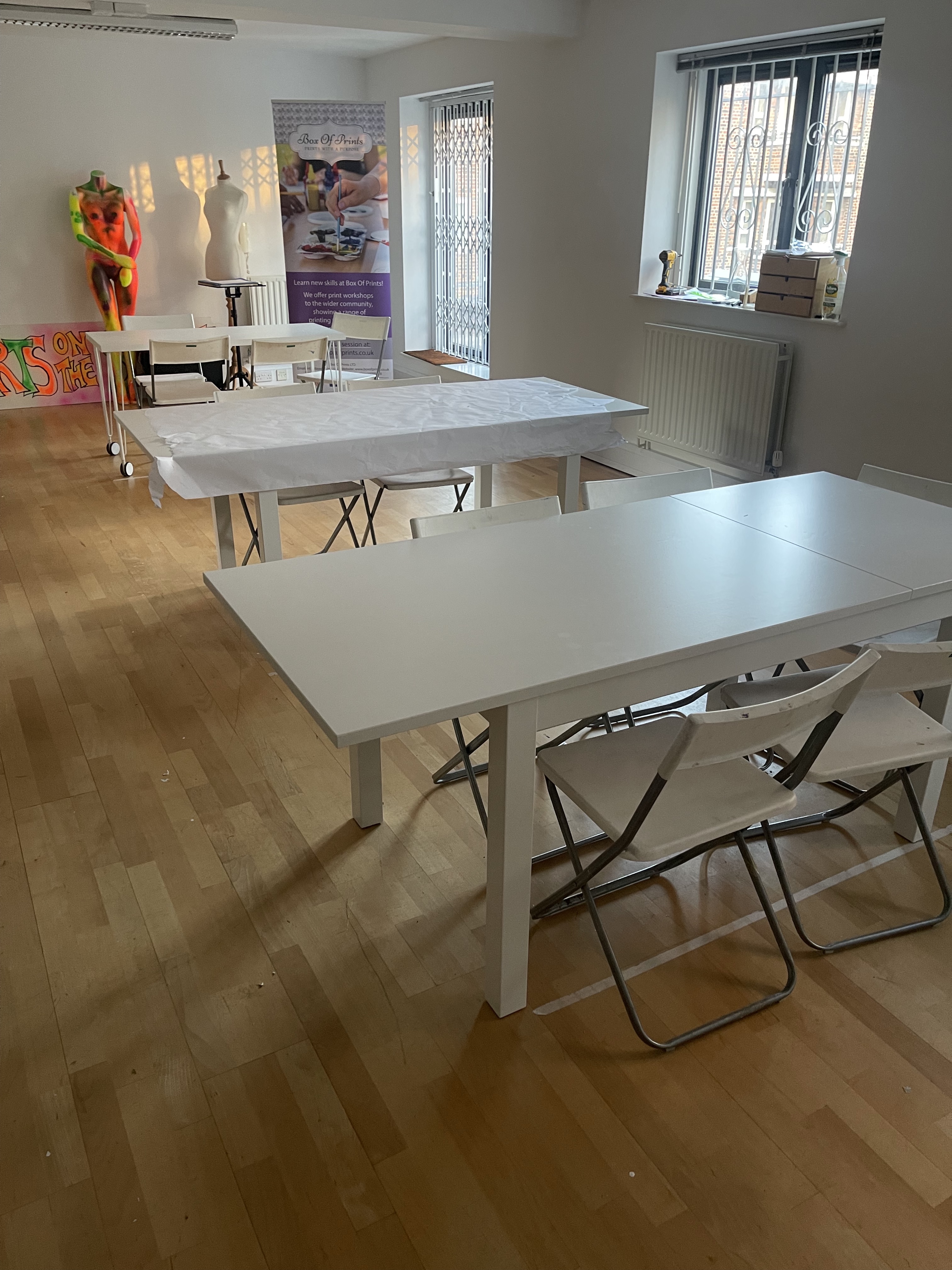 Minimalist meeting space with white tables, ideal for workshops and collaborative events.