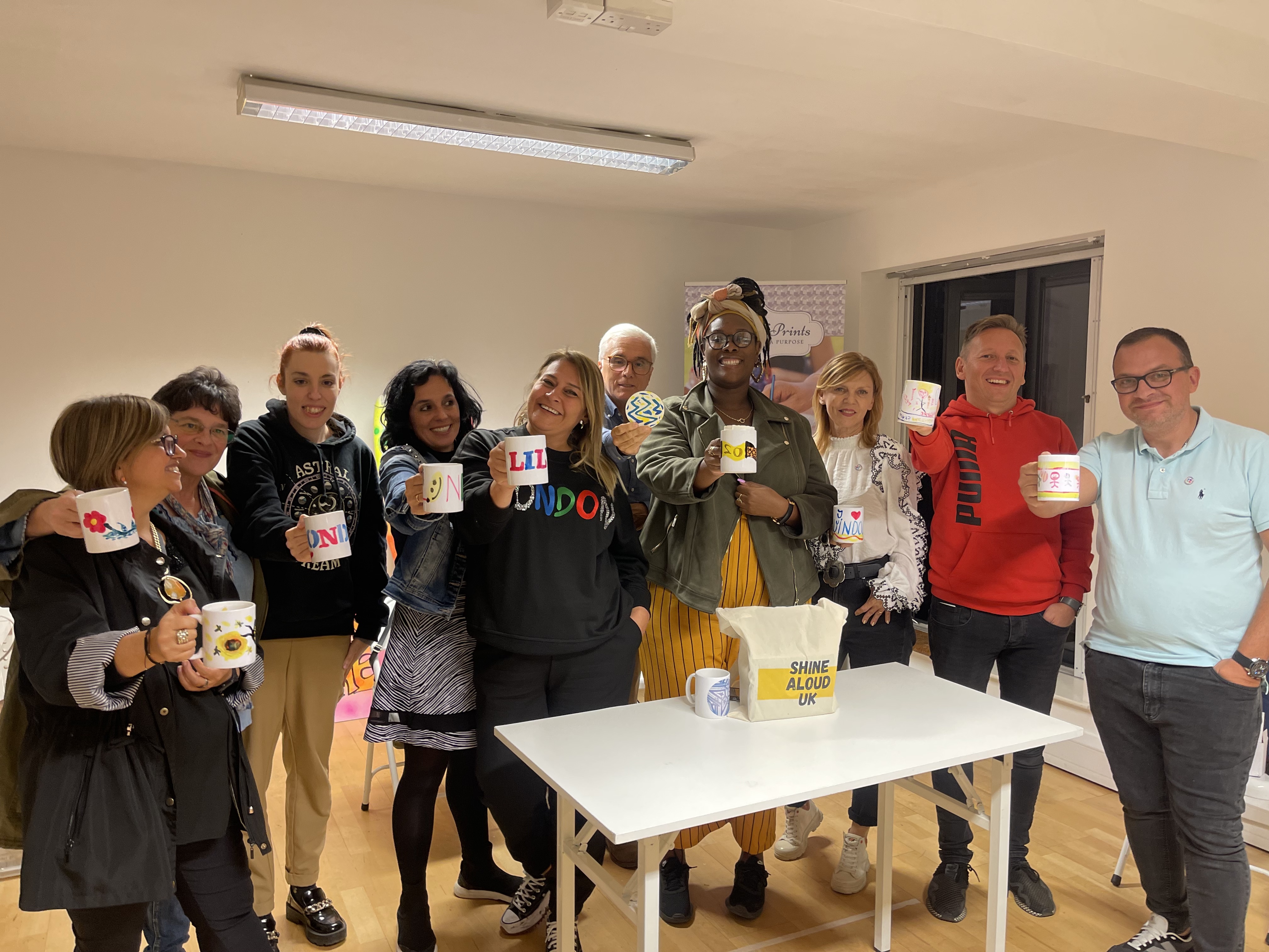 Diverse attendees celebrate with personalized mugs at The Bop Hub event.