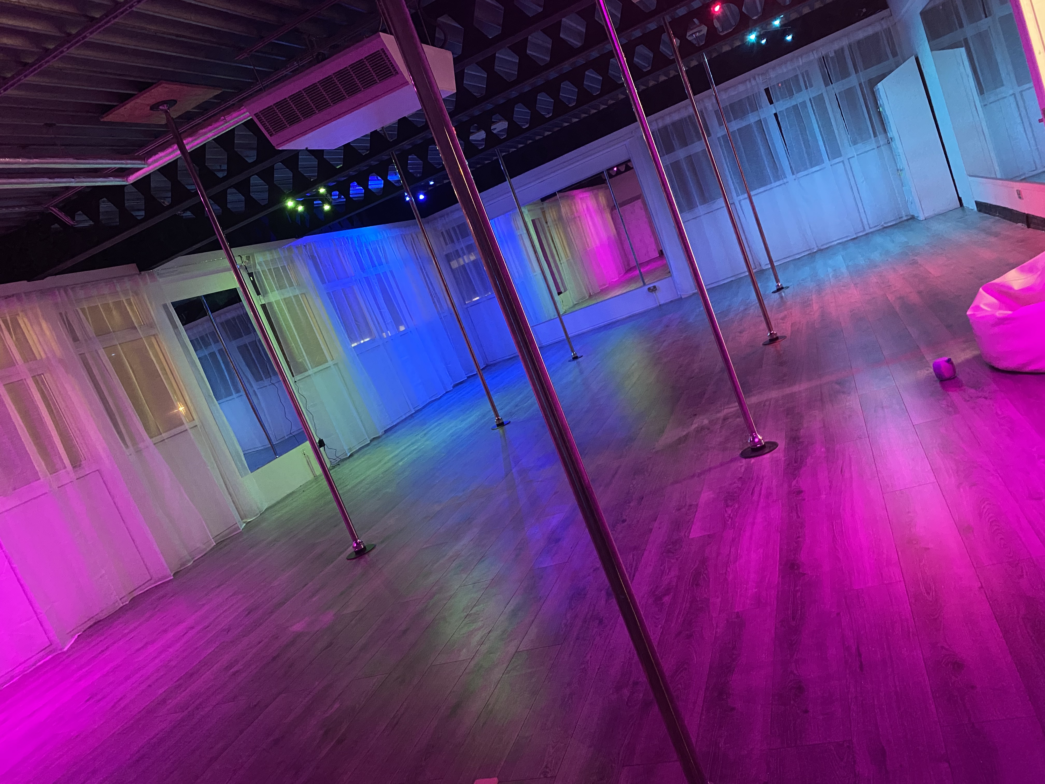 Versatile event space with polished wooden floors for fitness classes and workshops.