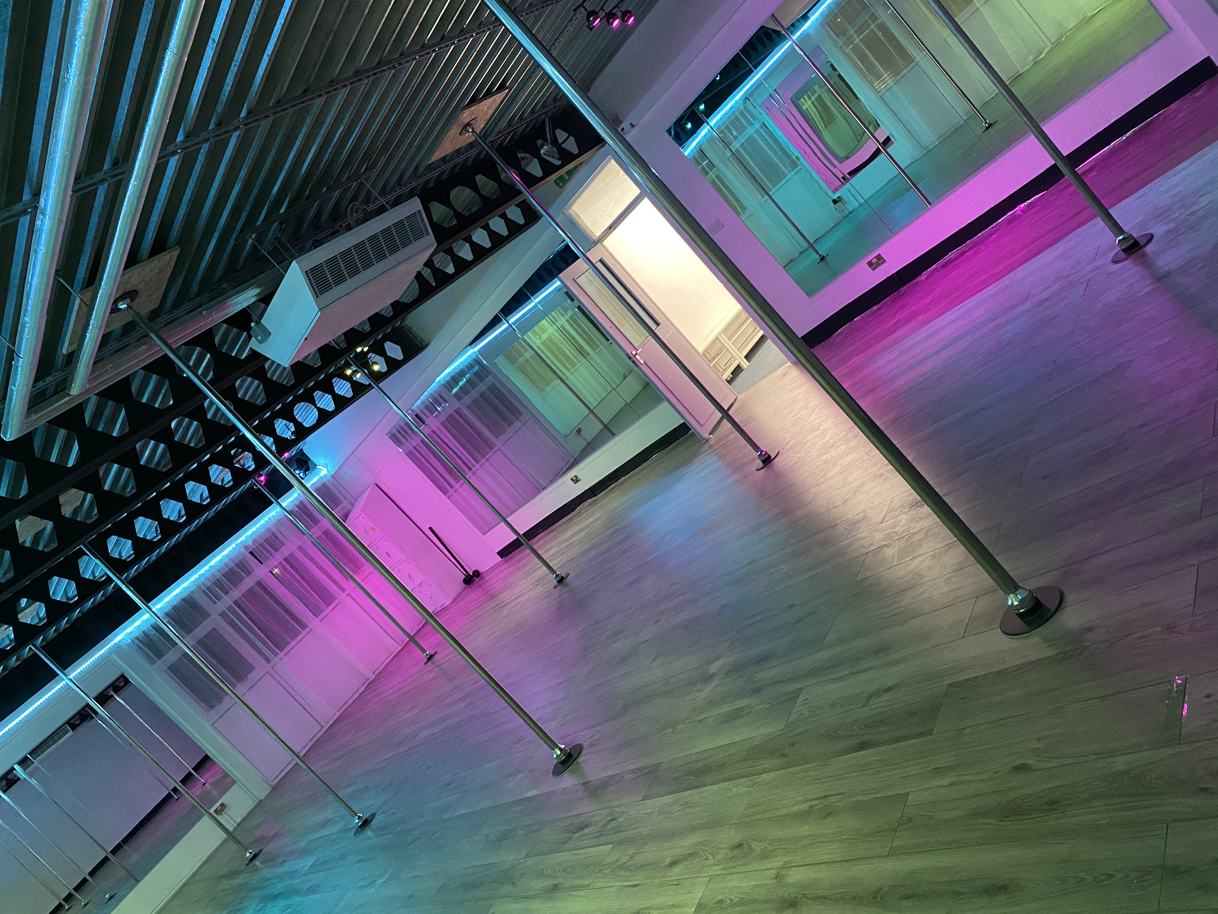 Versatile event space with wooden flooring, ideal for corporate meetings and social gatherings.