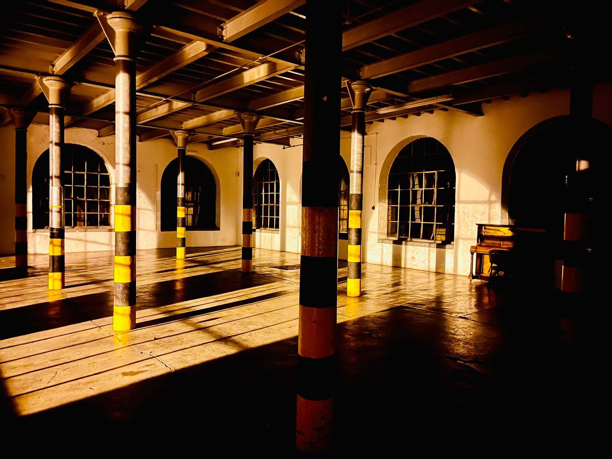 Spacious industrial venue with high ceilings for creative events and workshops.