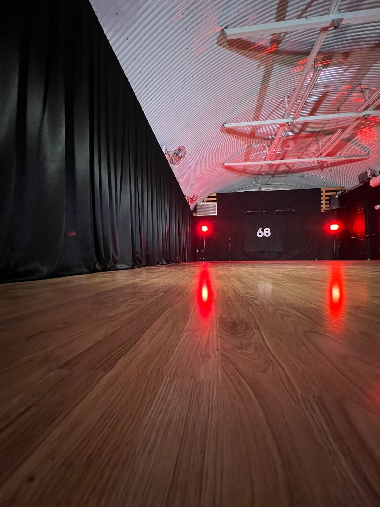 Versatile event space in Studio 68 London with polished wood floors and dramatic lighting.
