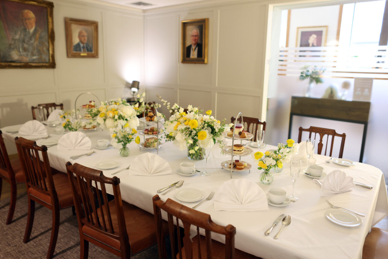 Elegant private dining room with floral centerpieces for corporate events.