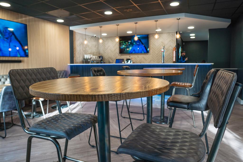 Modern sports bar with wooden tables, ideal for networking events and gatherings.