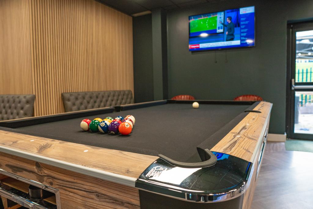 Stylish billiards table in modern sports bar for networking and team-building events.