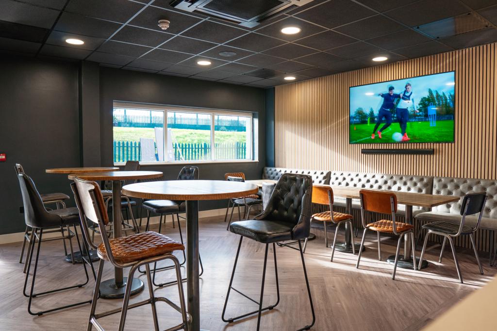 Modern sports bar with high-top tables, ideal for networking events and meetings.