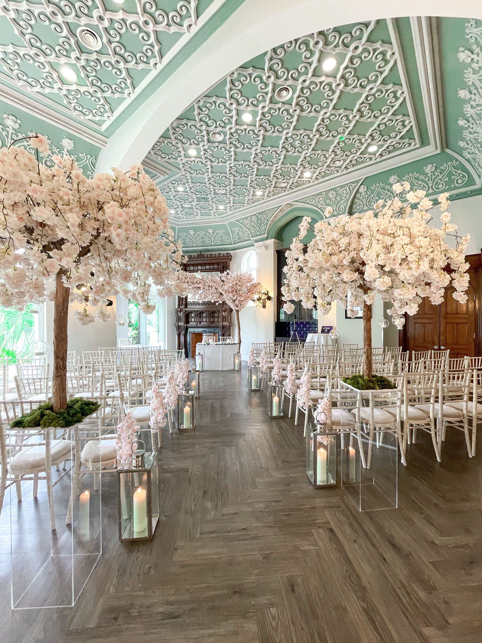 Elegant wedding venue with floral trees and white chairs at Oddfellows On The Park.
