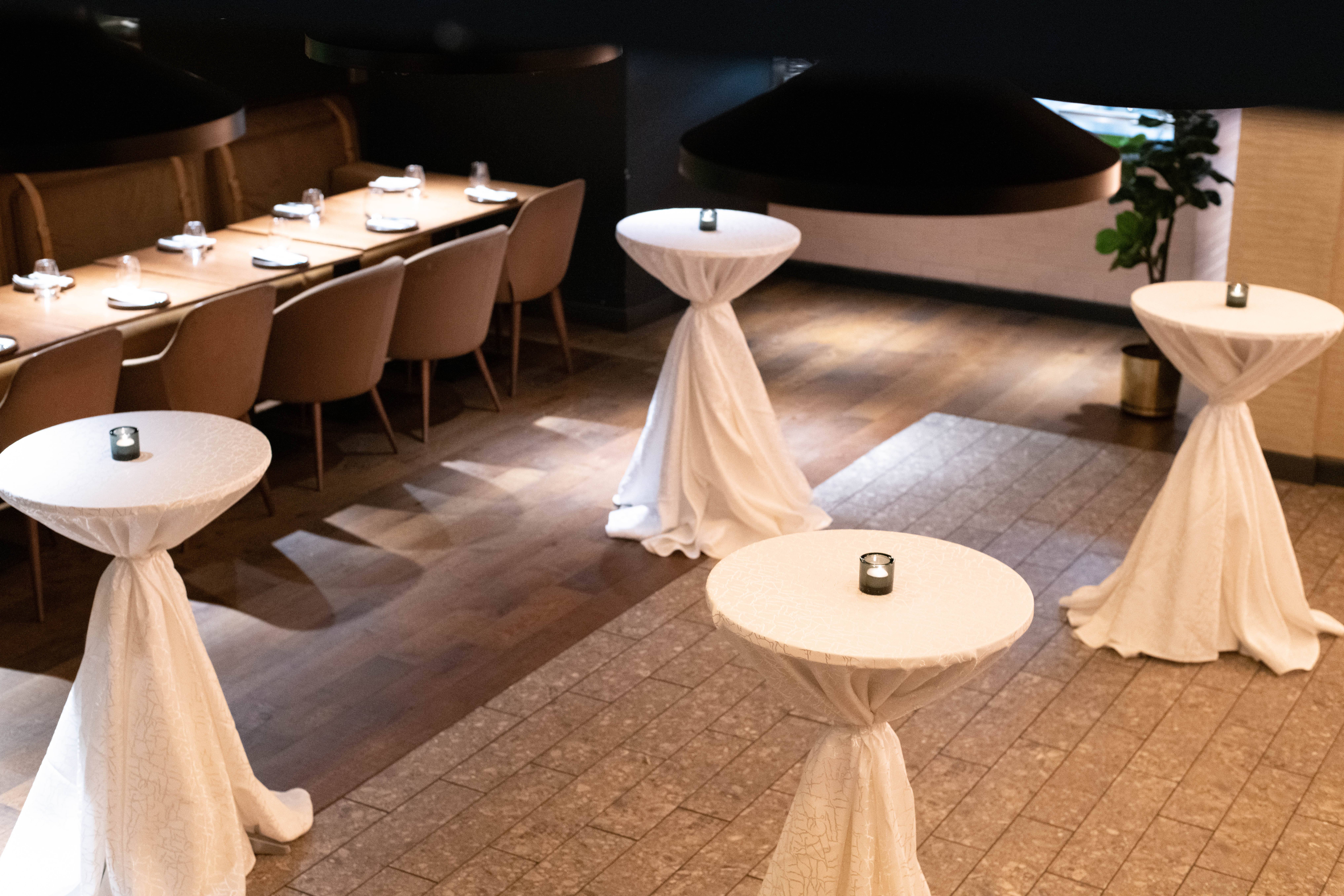 Stylish event space in Farzi London with elegant cocktail tables for upscale gatherings.